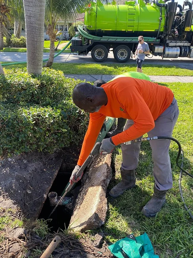 septic service tech cleaning a tank in Hollywood, FL