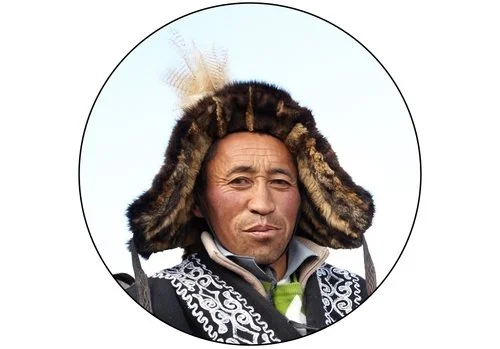 Close-up of a man wearing traditional Māori war headdress with feathers and ornate black and white clothing.