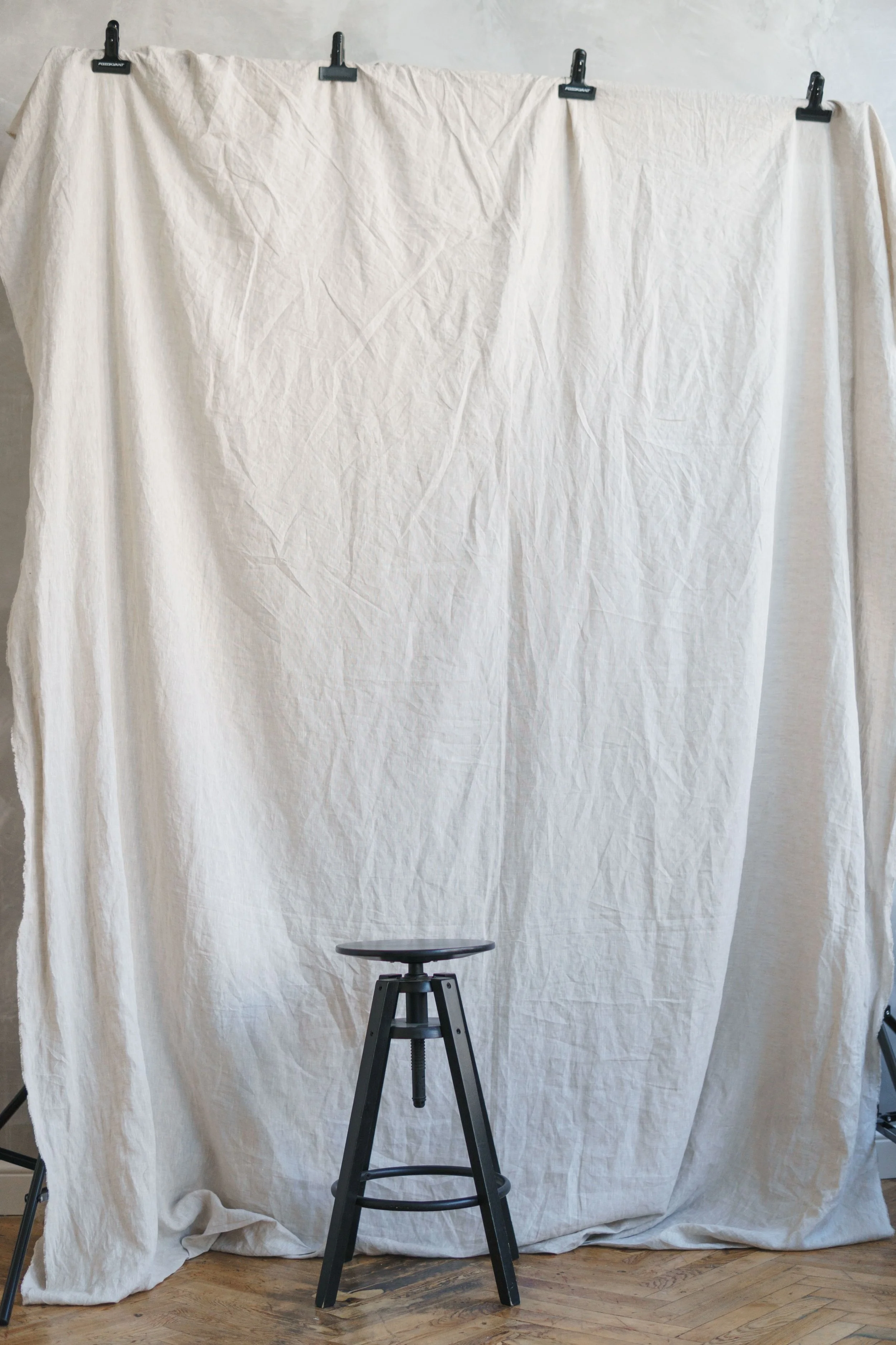 A stool in front of a white backdrop.