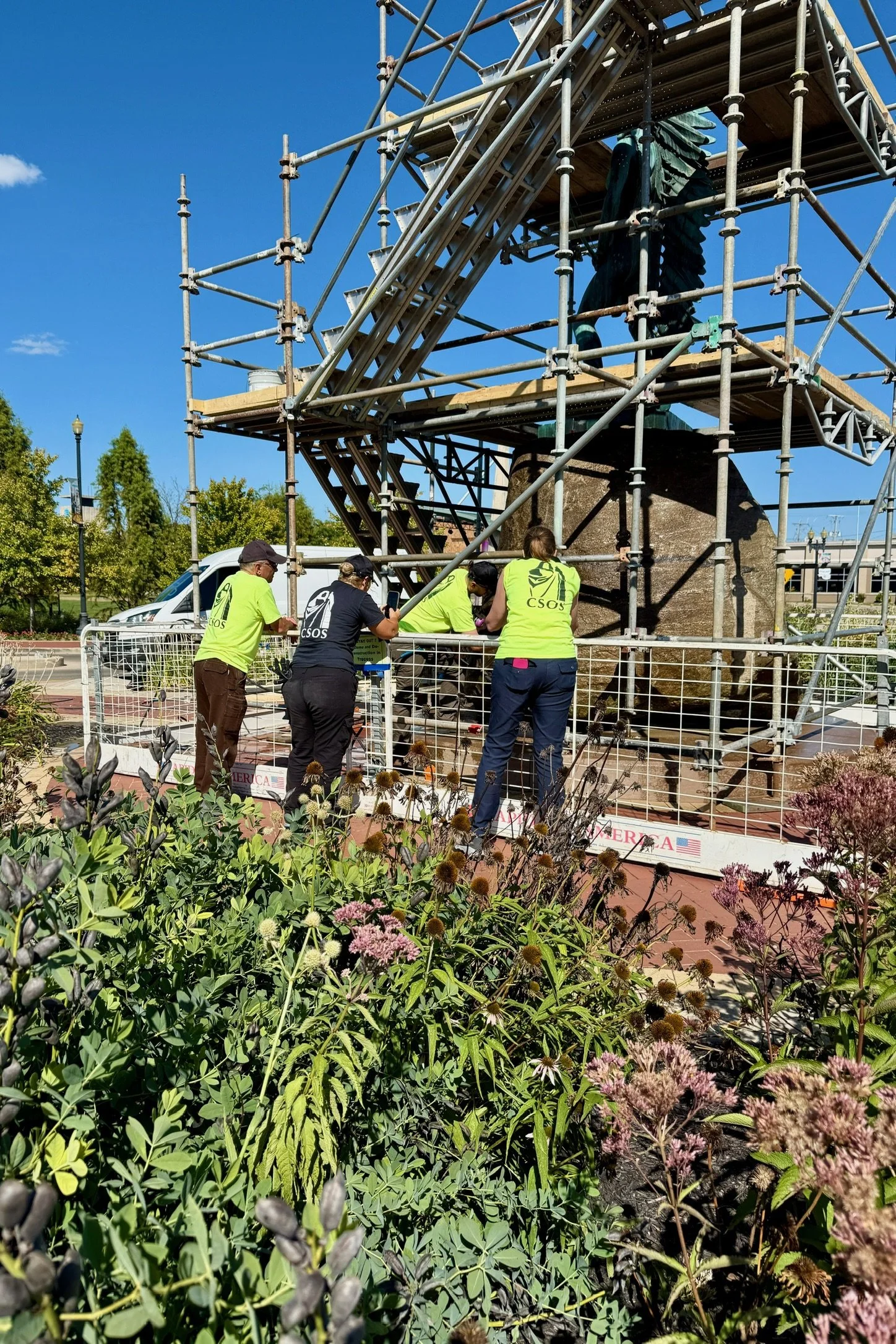 Workers restoring The Passing of the Buffalo statue