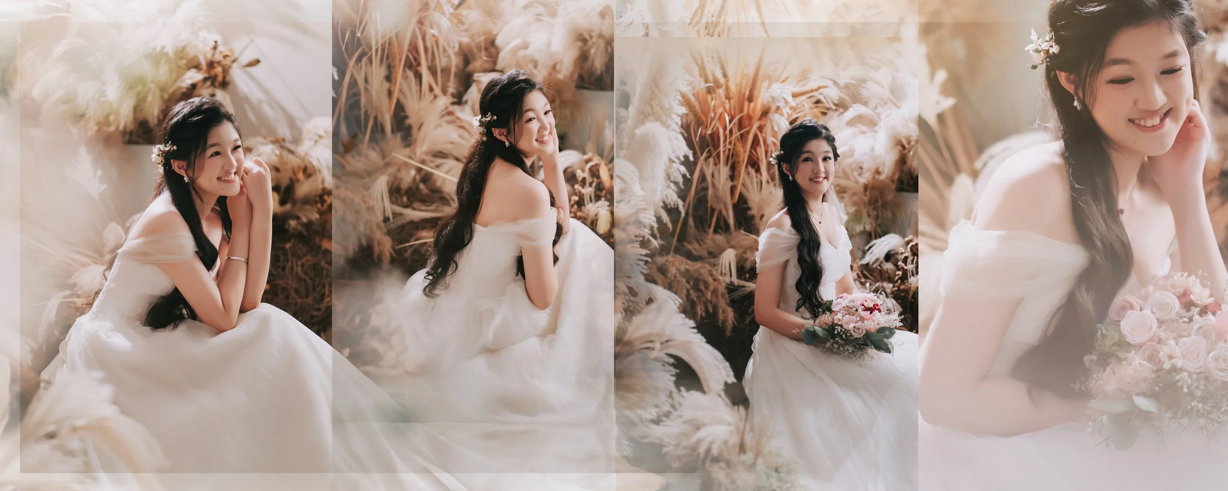 A woman in a white wedding dress with long black hair, sitting among beige dried plants, smiling and holding a bouquet of pink roses.