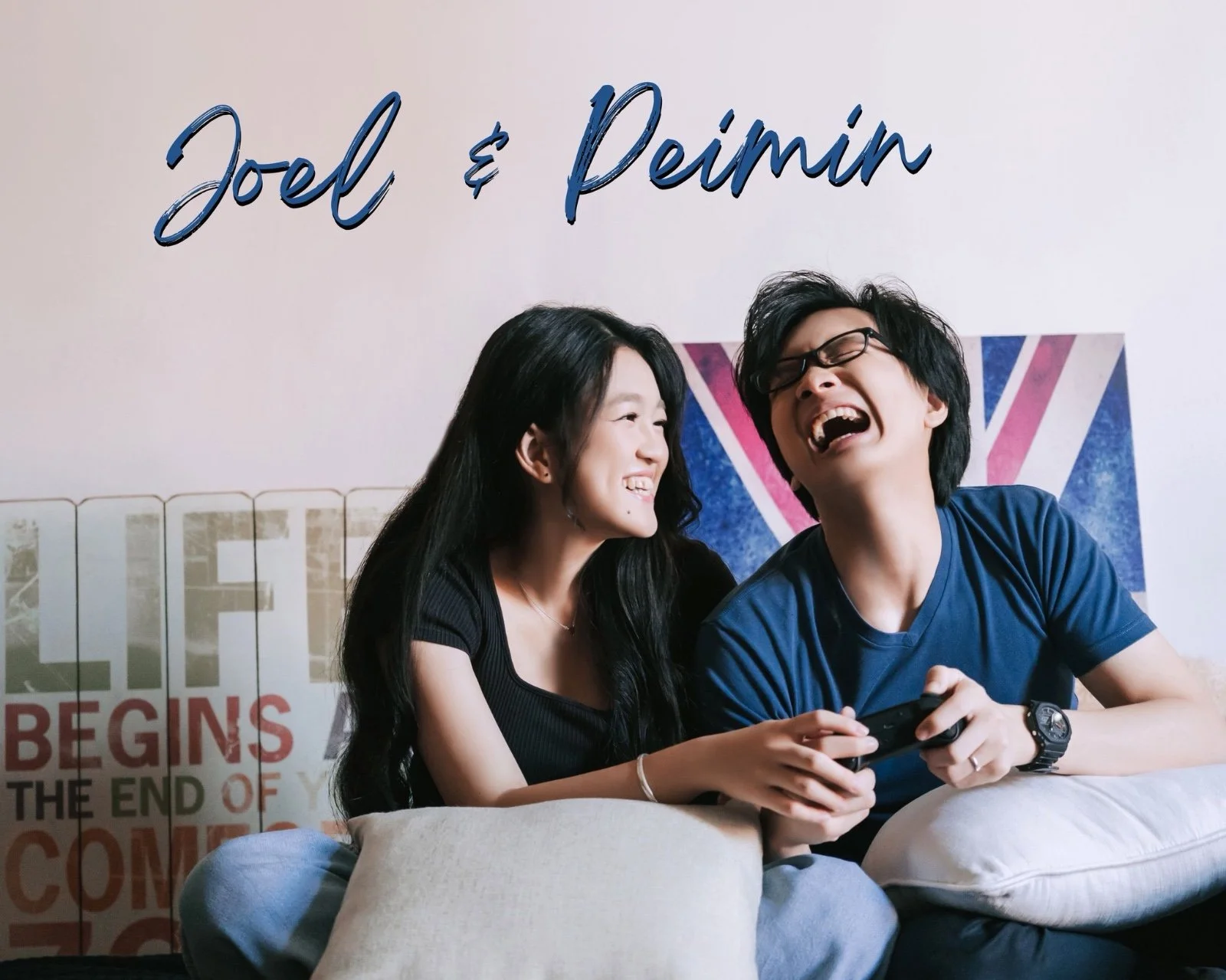 A young woman and man sitting on a sofa, laughing, with the woman holding a gaming controller, and a Union Jack flag in the background.