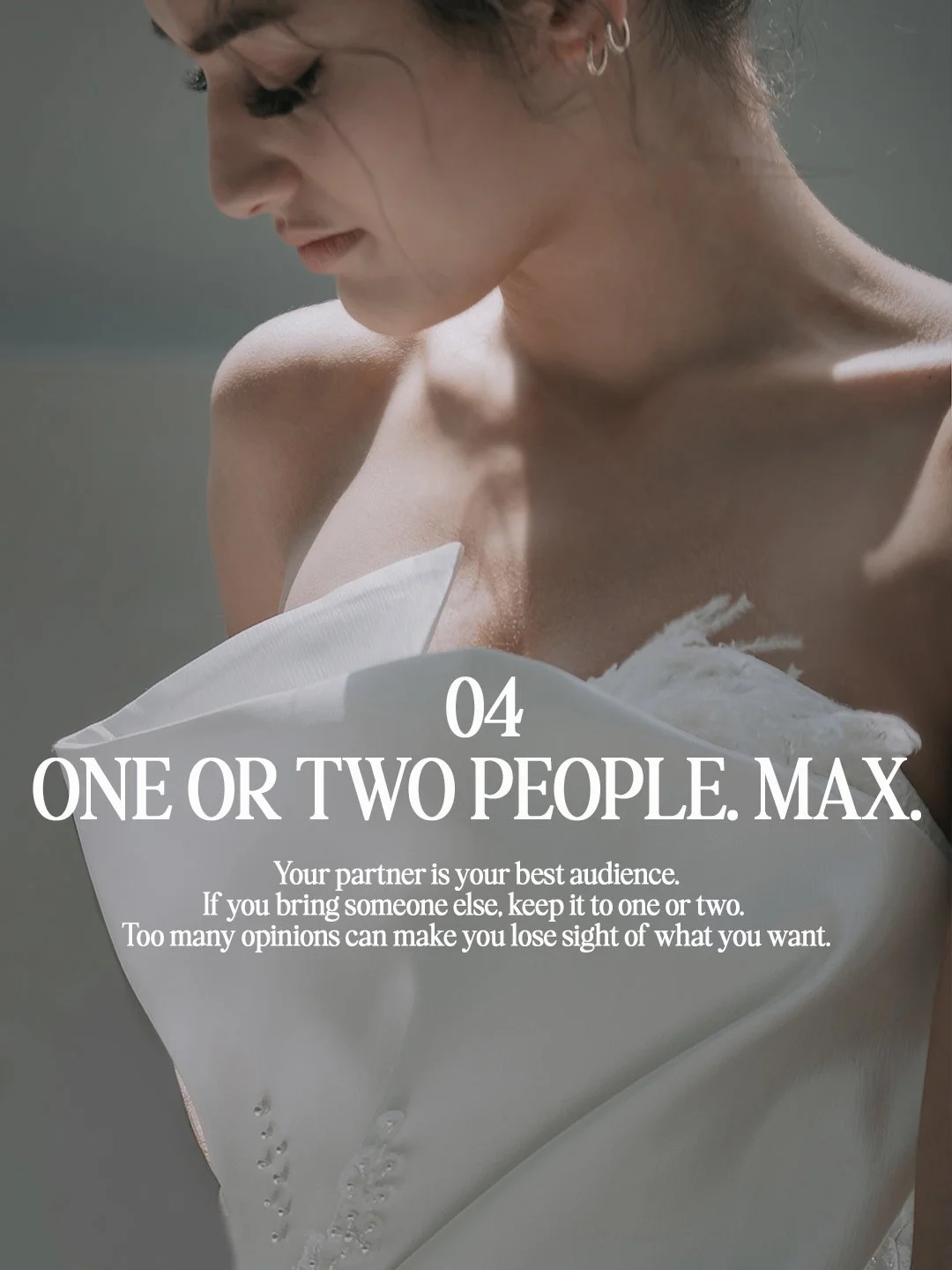 Close-up of a structured sculptural bridal gown neckline with feather details