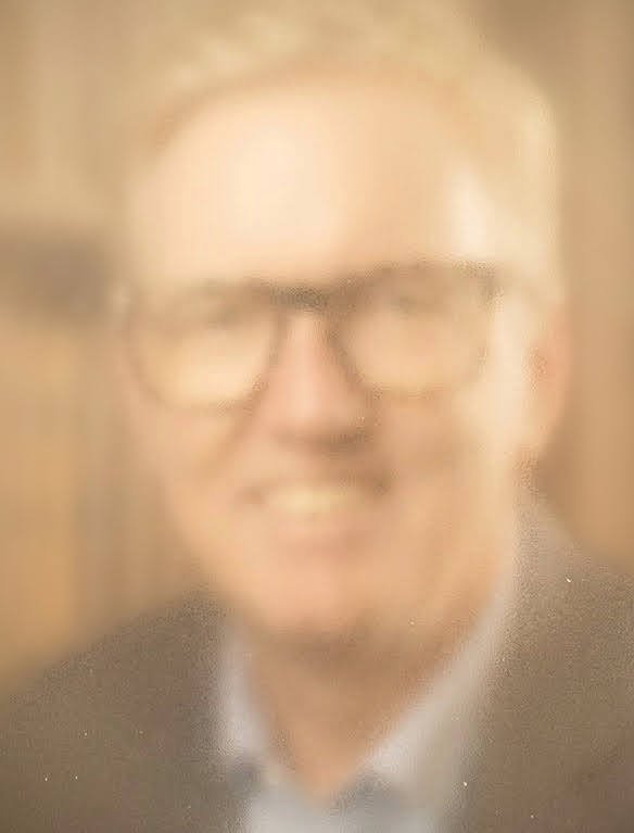 Sven, Lotse für den Ruhestand, lächelt in einem unscharfen Porträtfoto mit Brille.