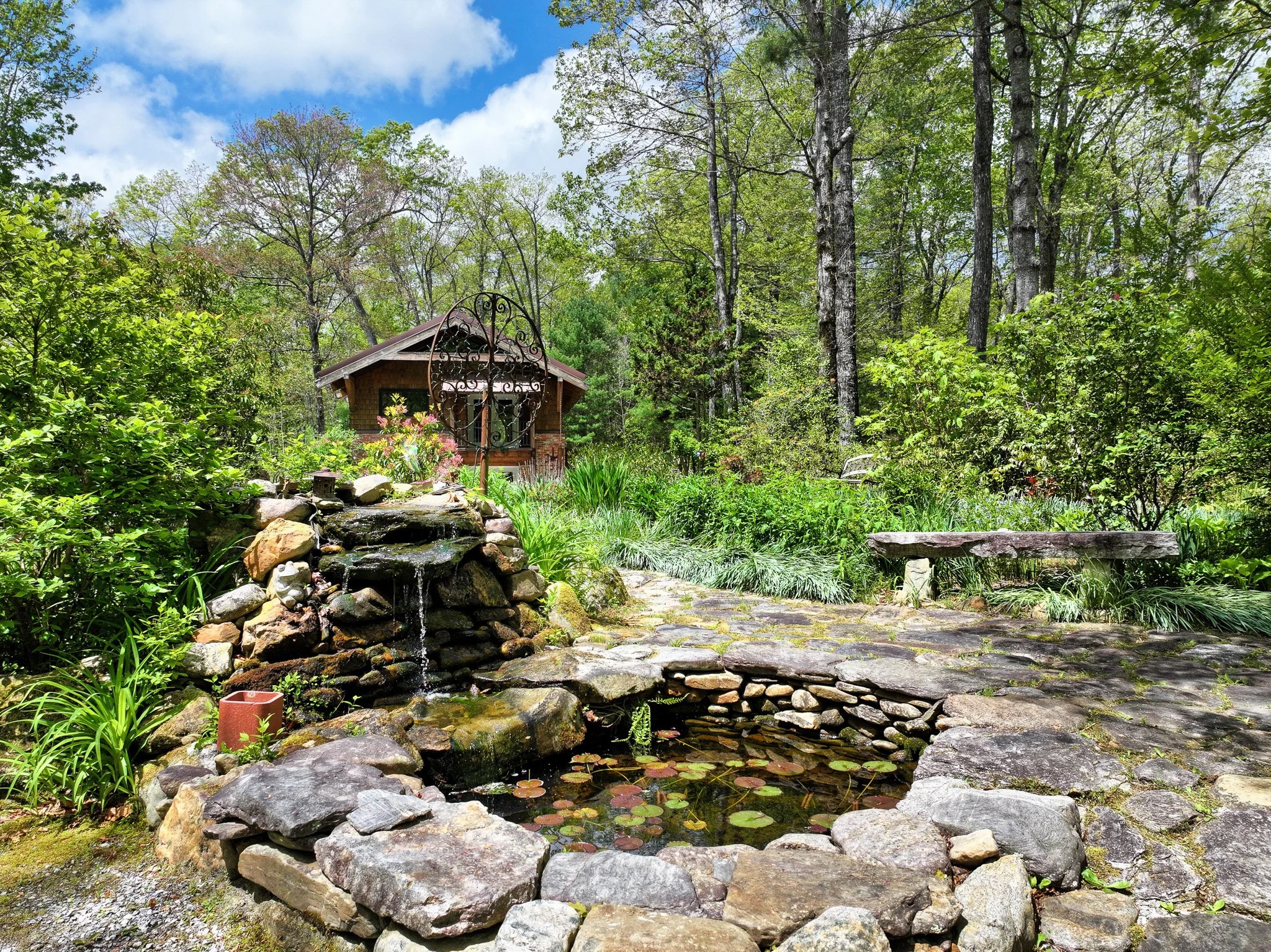 Fountain and landscaping near the entry to the main home and 2-story brick building