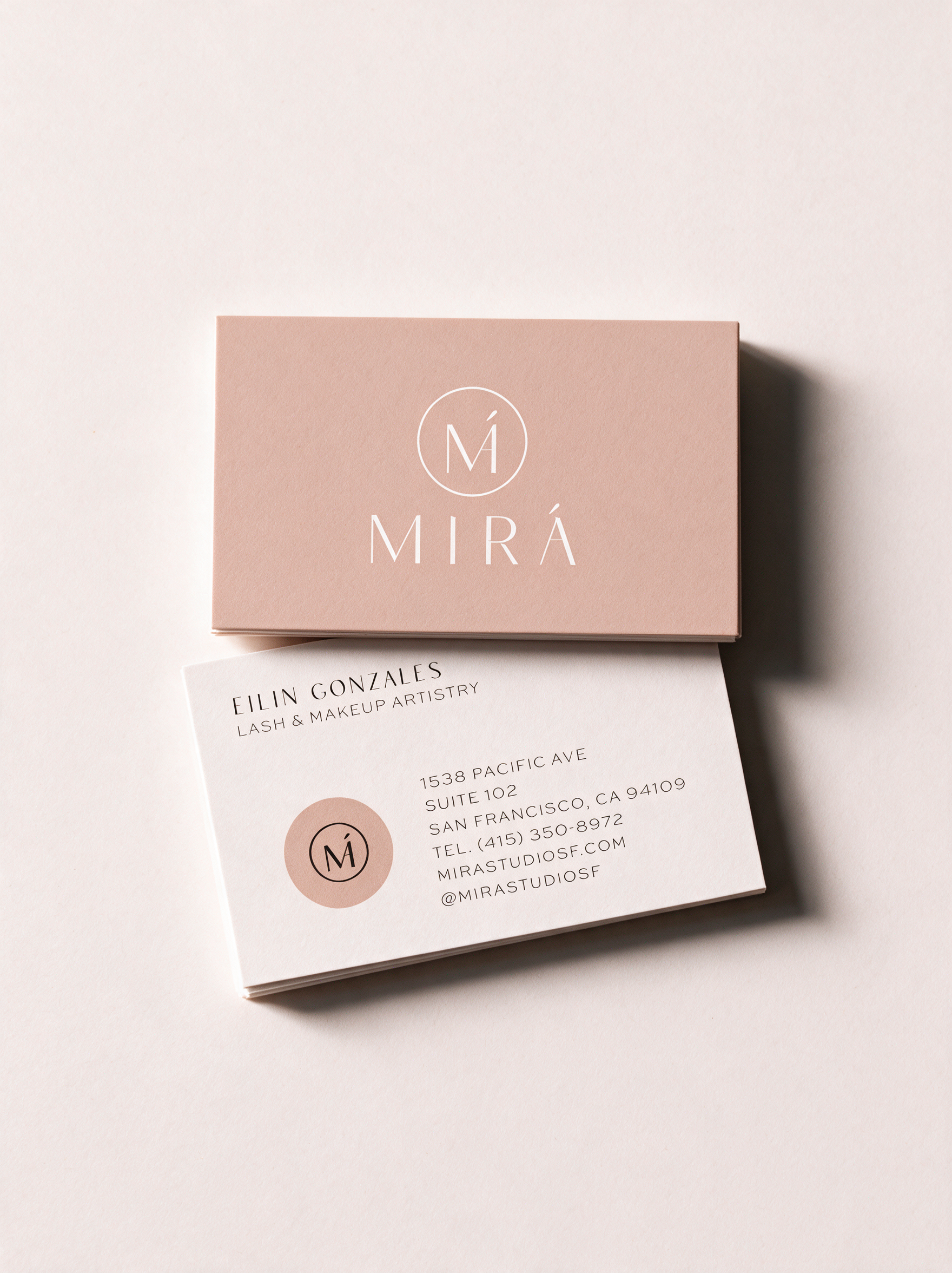 Business card and pink box with logo on light background.