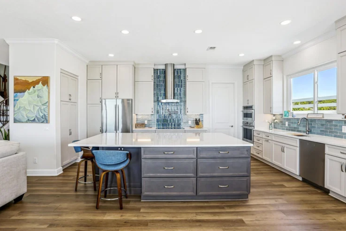 ckd-remodeling-pensacola-beach-fl-kitchen-must-have-features-blue-and-white-cabinets-large-island-ocean-view-backsplash-feature-custom-design-build.png
