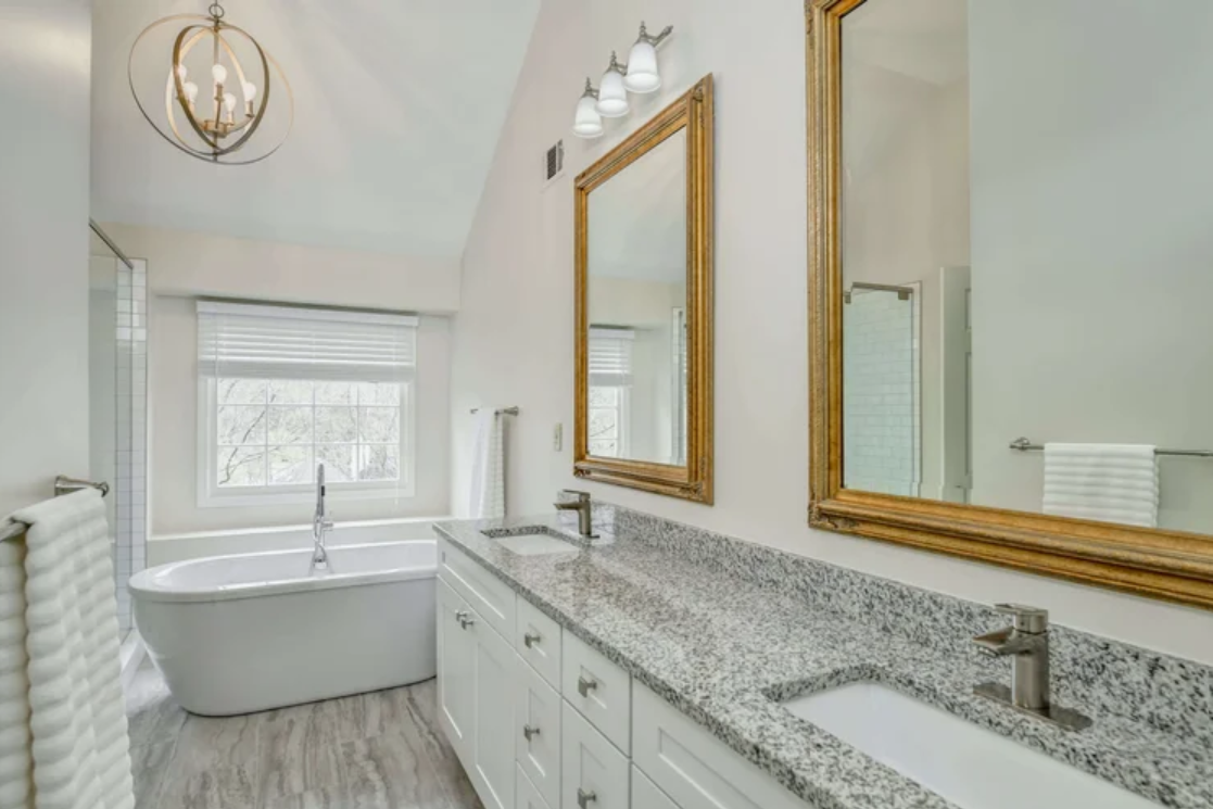 ckd-remodeling-pensacola-fl-lighting-impact-on-paint-colors-primary-bathroom-soaking-tub-by-window-stone-countertop-fresh-home-remodel.png