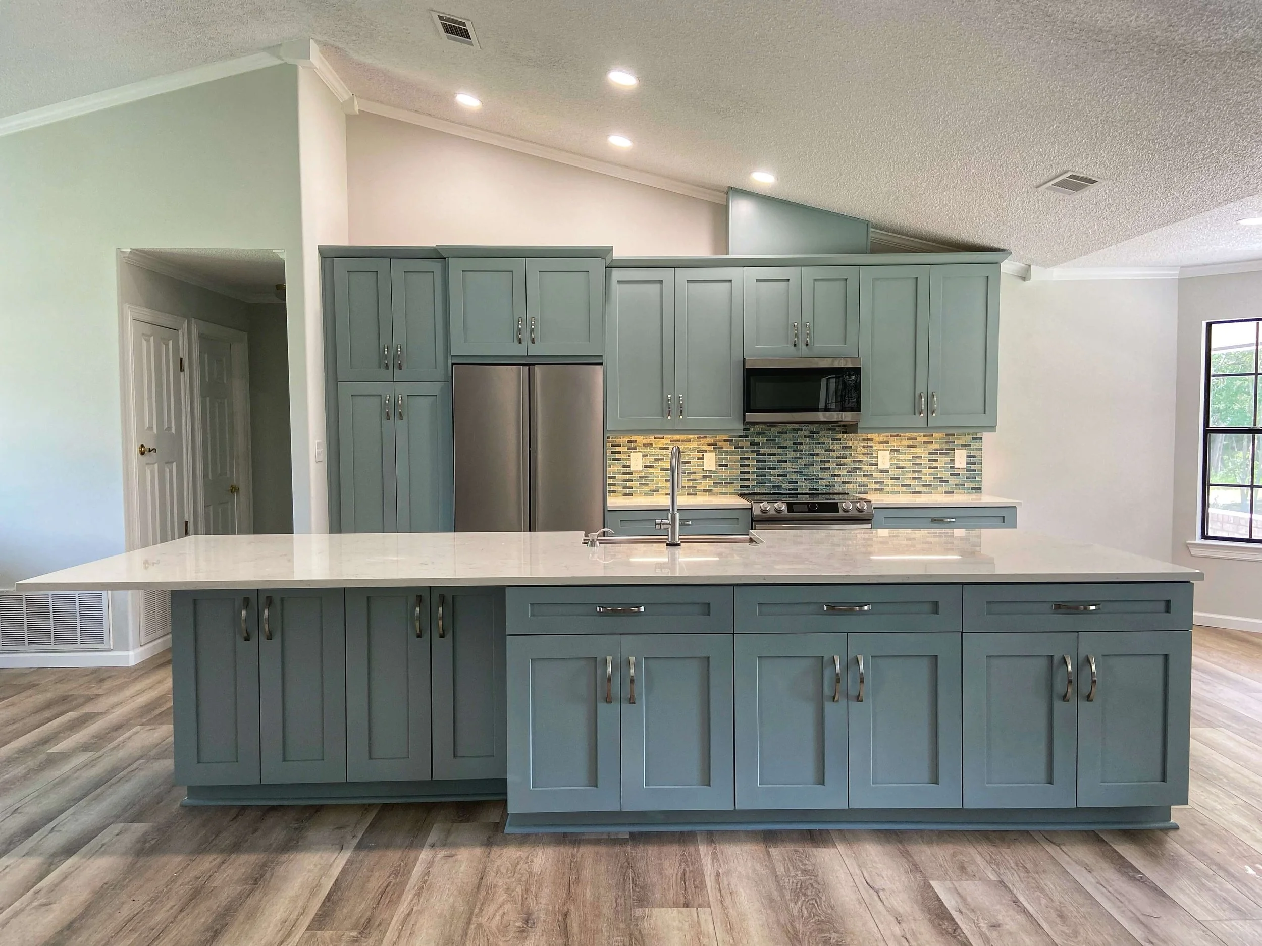 design-build-bathroom-renovation-pensacola-fl-colorful-kitchen-cabinets-and-backsplash-large-kitchen-wood-floors-sage-green-cabinets-vaulted-ceiling.jpg