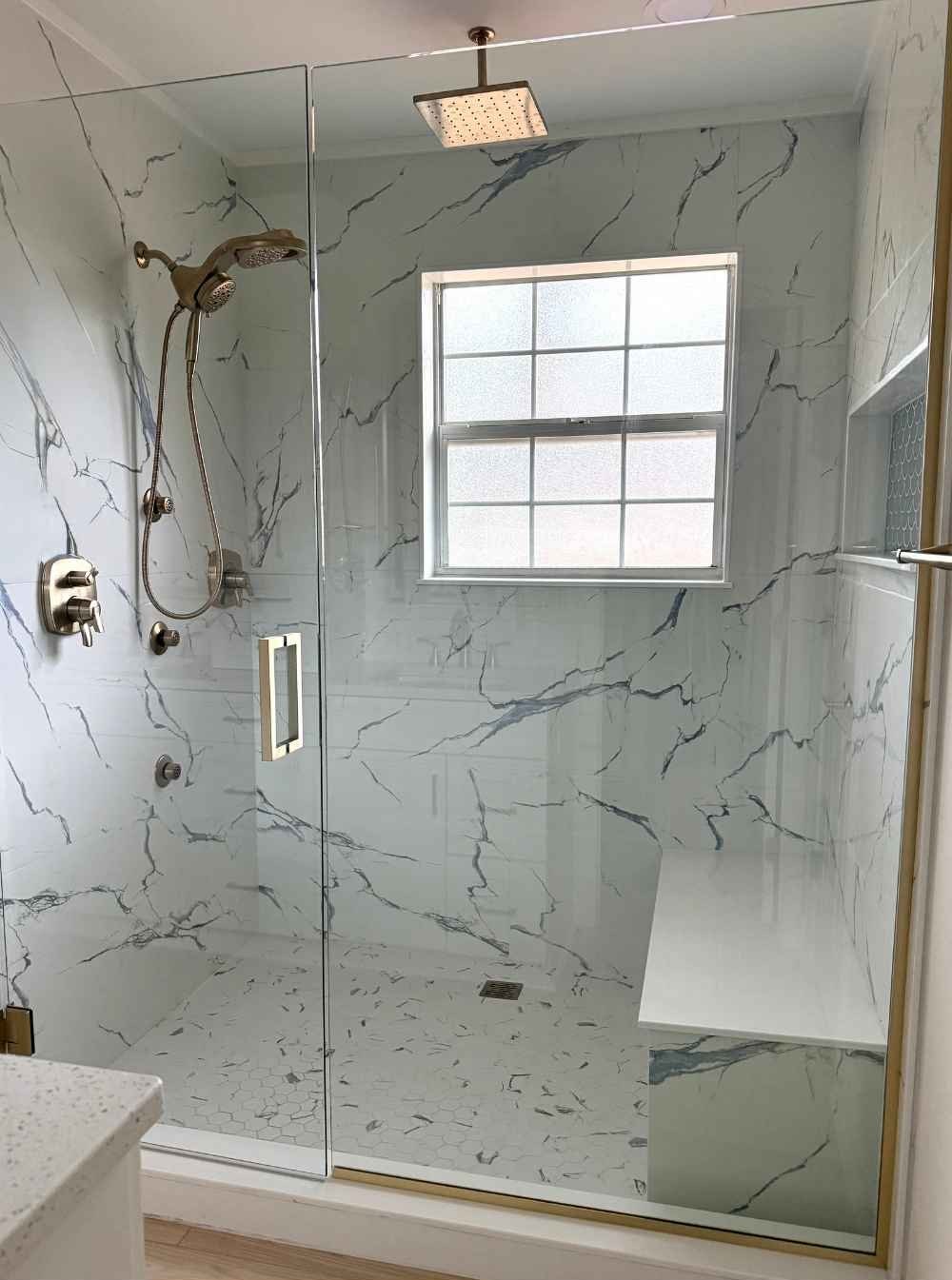 ckd-remodeling-milton-fl-full-gut-renovation-bathroom-large-bathroom-shower-large-tile-bench-and-window-glass-door-quality-design-build.jpg