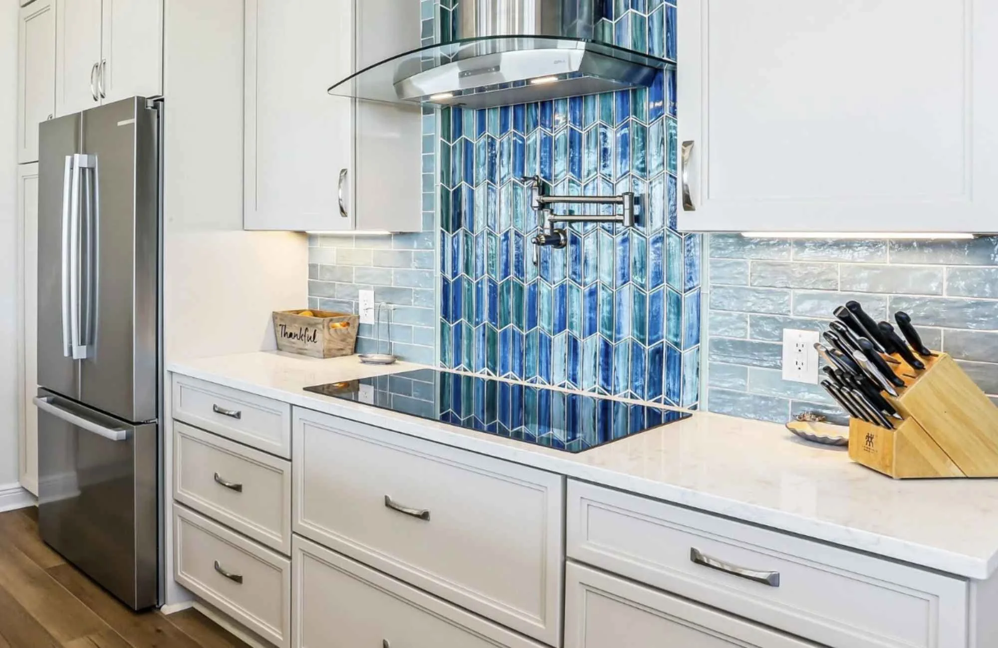 ckd-remodeling-pace-fl-backsplash-materials-coastal-kitchen-with-white-cabinets-bright-blue-vertical-backsplash-tile-by-cooktop-precise.jpg