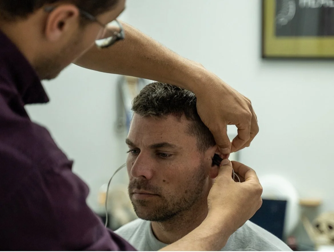 Health professional administering non-invasive vagus nerve stimulation therapy to a patient for the treatment of anxiety, depression, PTSD, and related conditions.