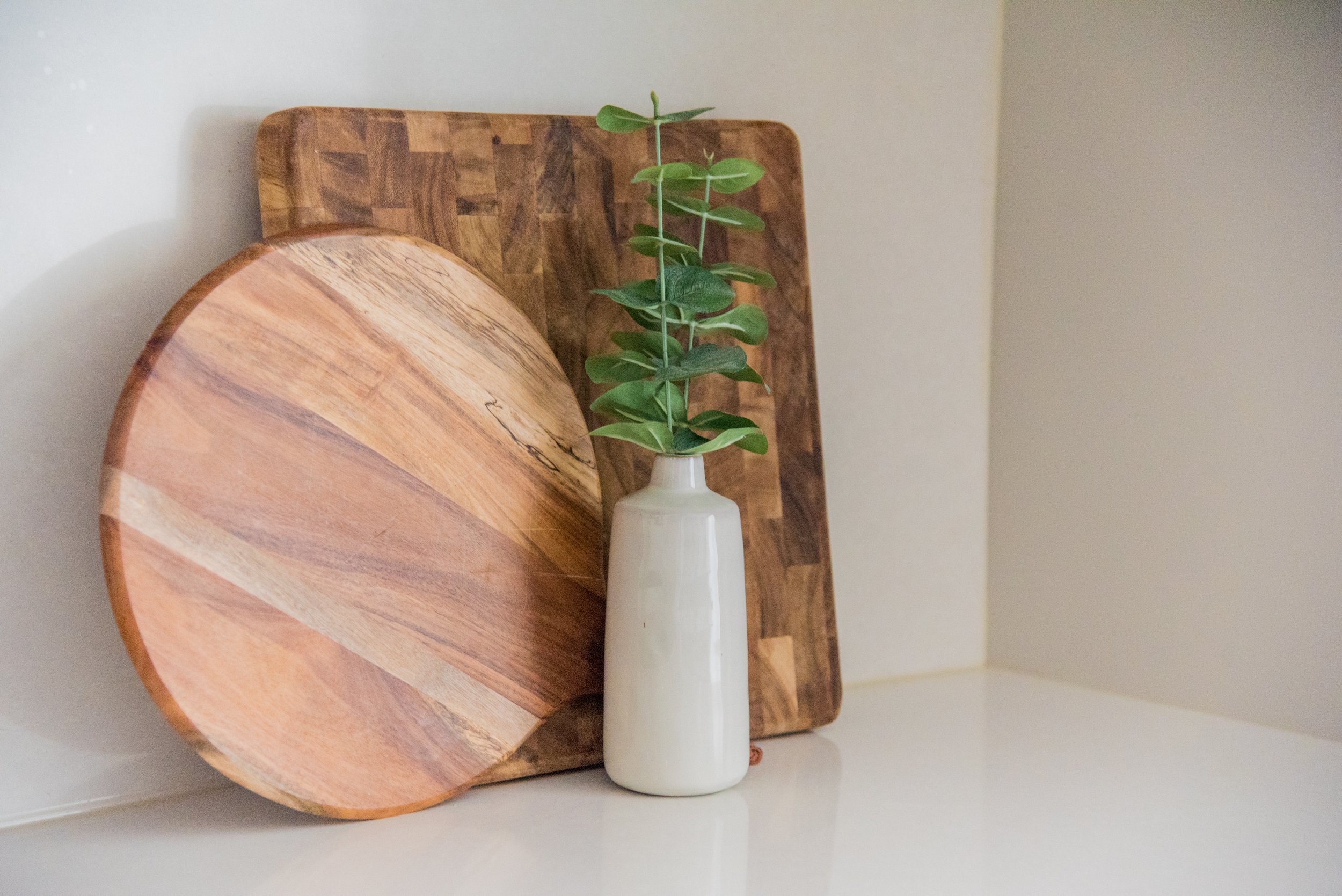 wood accents and a white vase on the kitchen counter