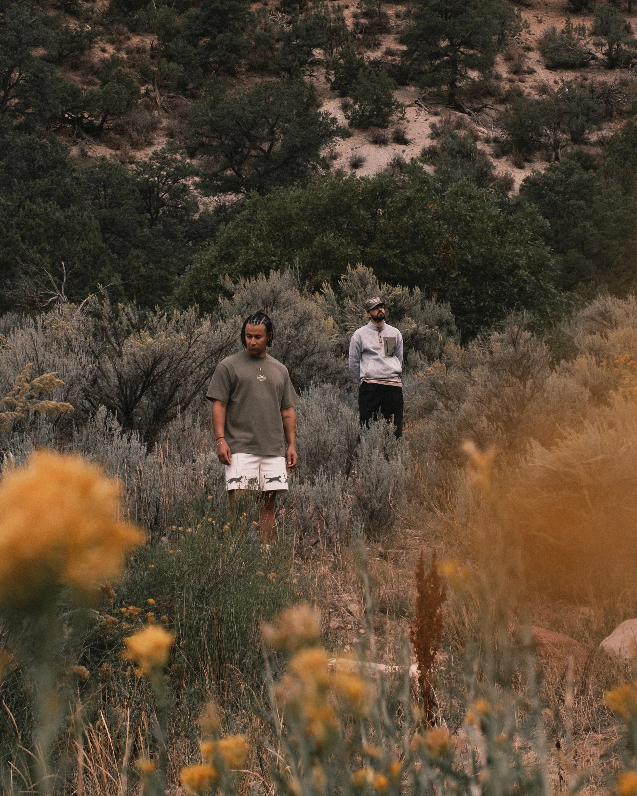 Two golfers in PUMA Golf x GGNC Field Notes apparel among sagebrush and wildflowers in the Rocky Mountains