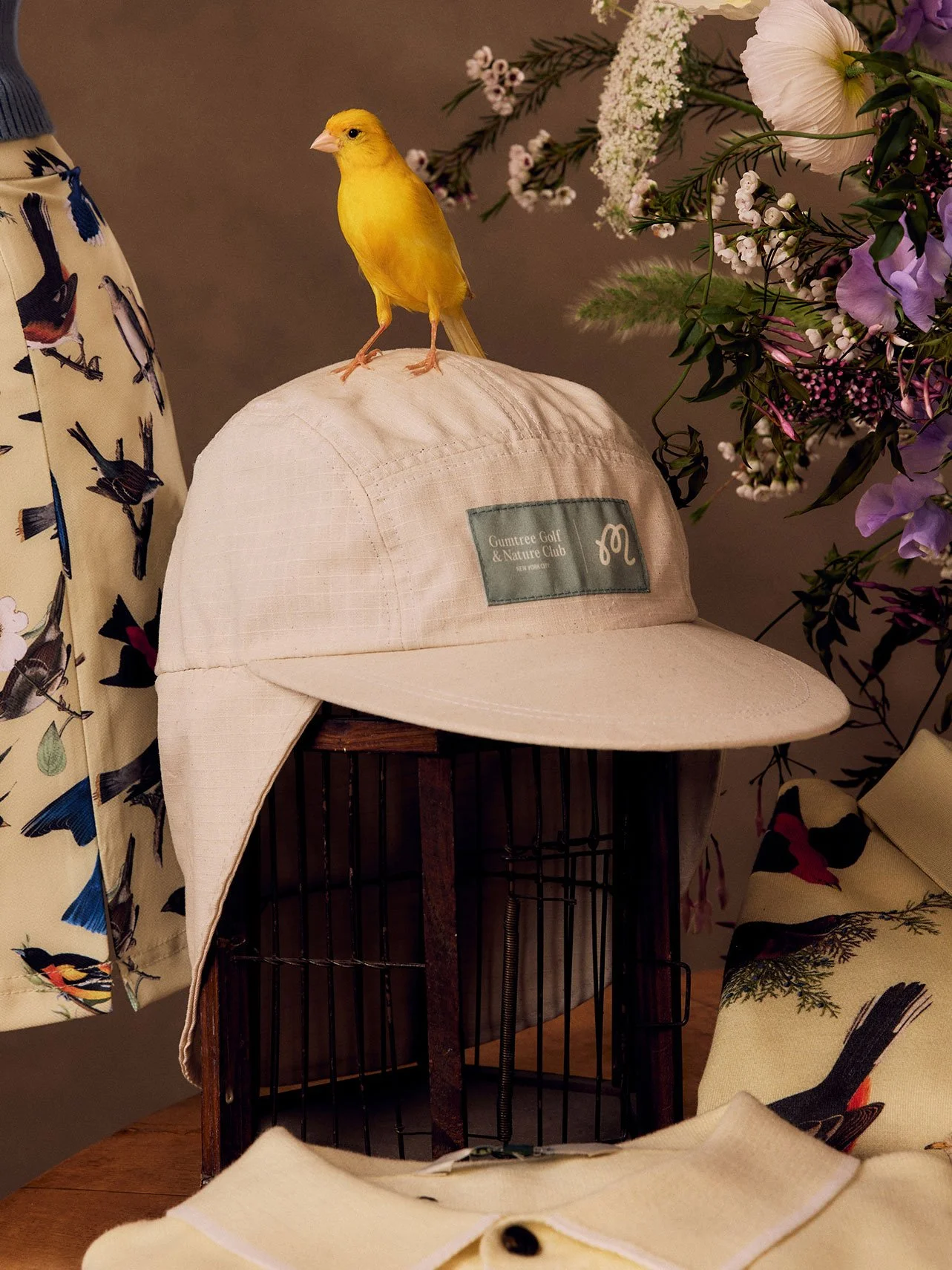 Malbon x GGNC Field Research long-bill hat with a canary and spring flowers