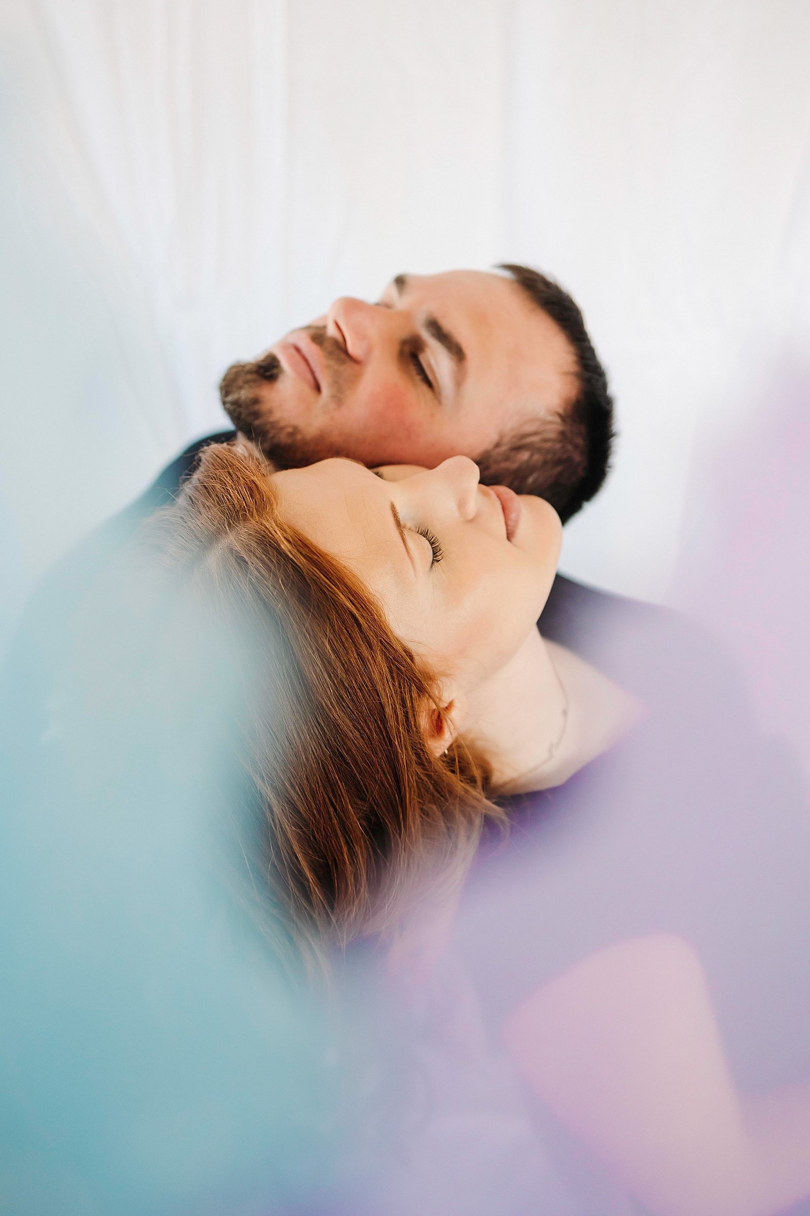  Husband and wife leaning on each other at their color connection couples session 