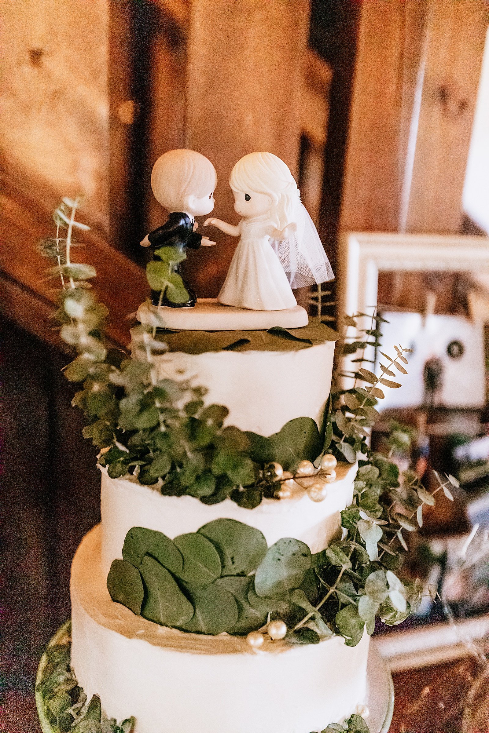  Three tier white wedding cake with greenery and custom toppers for wedding at Mayowood Stone Barn 