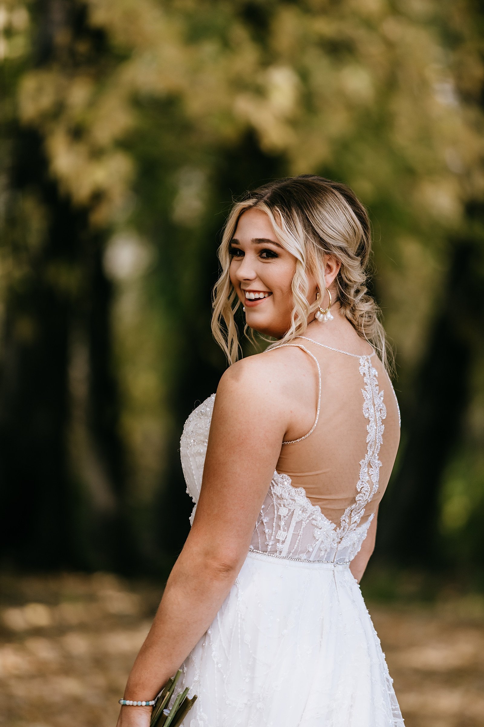  Bride smiling over her shoulder by Minneapolis wedding photographer, McKenzie Berquam 