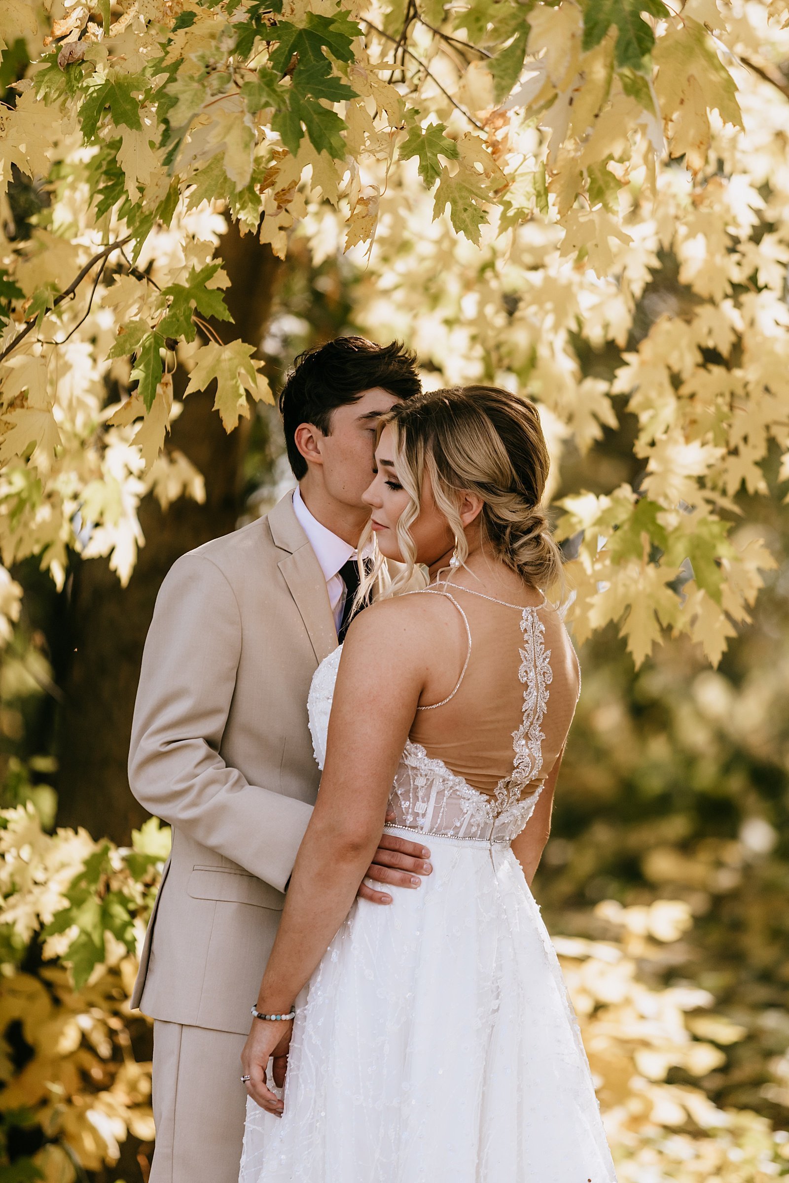  Bride and groom kissing under Fall foliage for their Minneapolis wedding 