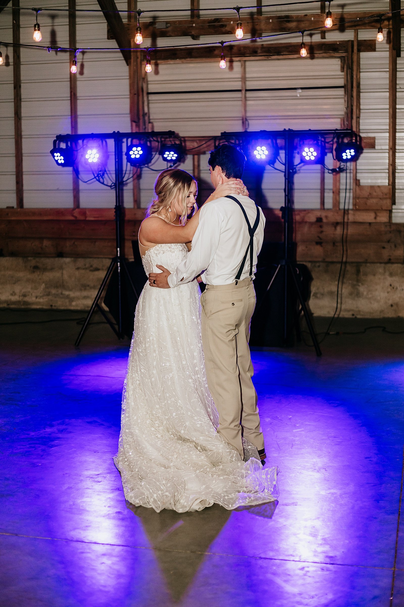  Newlyweds share a first dance under blue lights at their outdoor reception at The Cottage Farmhouse 