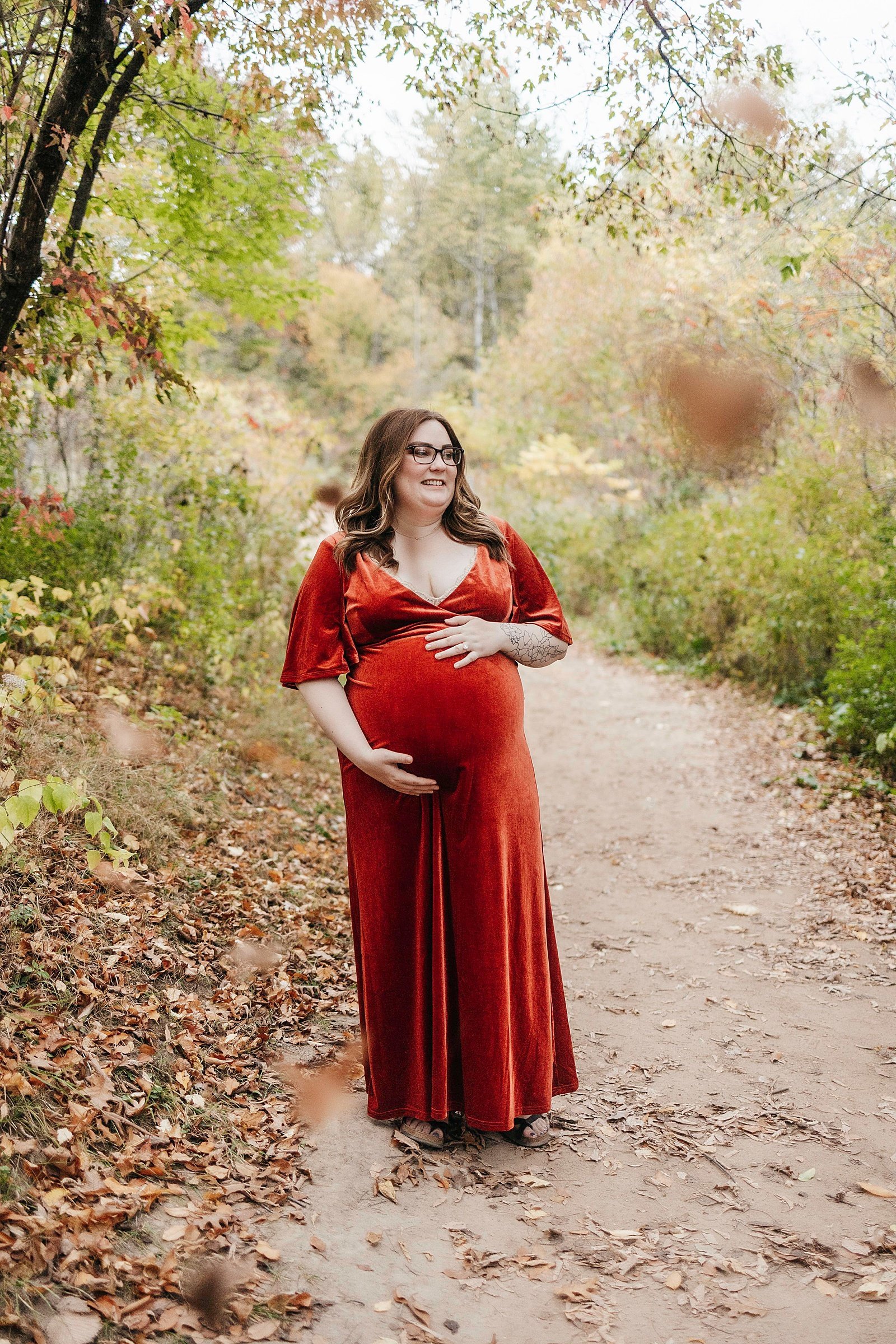  Pregnant woman in a red dress at her photo shoot with Minneapolis photographer, McKenzie Berquam. 
