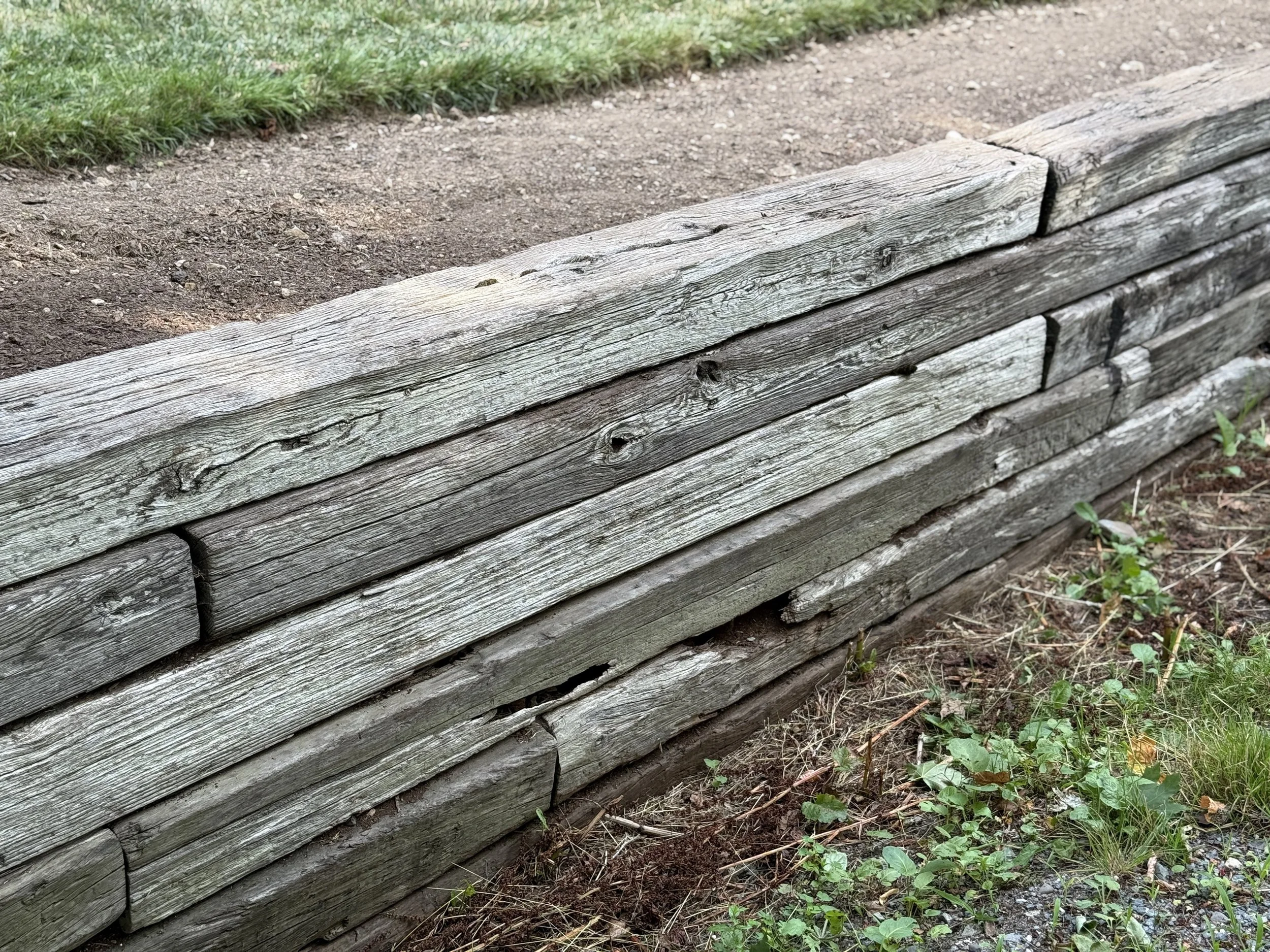 Timber and railroad tie retaining wall