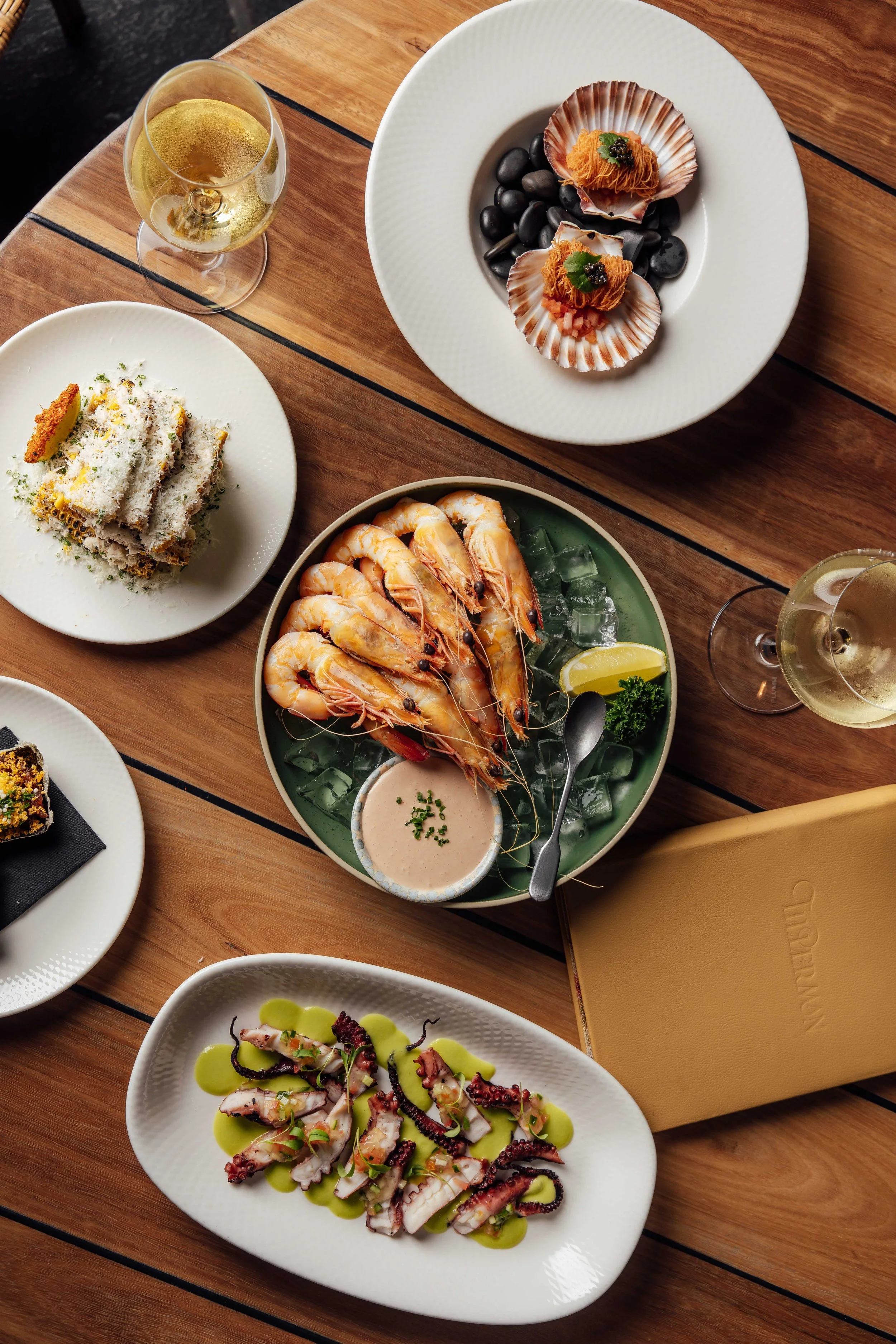 Fresh seafood dishes at Tillerman Seafood Restaurant Brisbane — scallops, prawns and octopus with wine on the Brisbane River