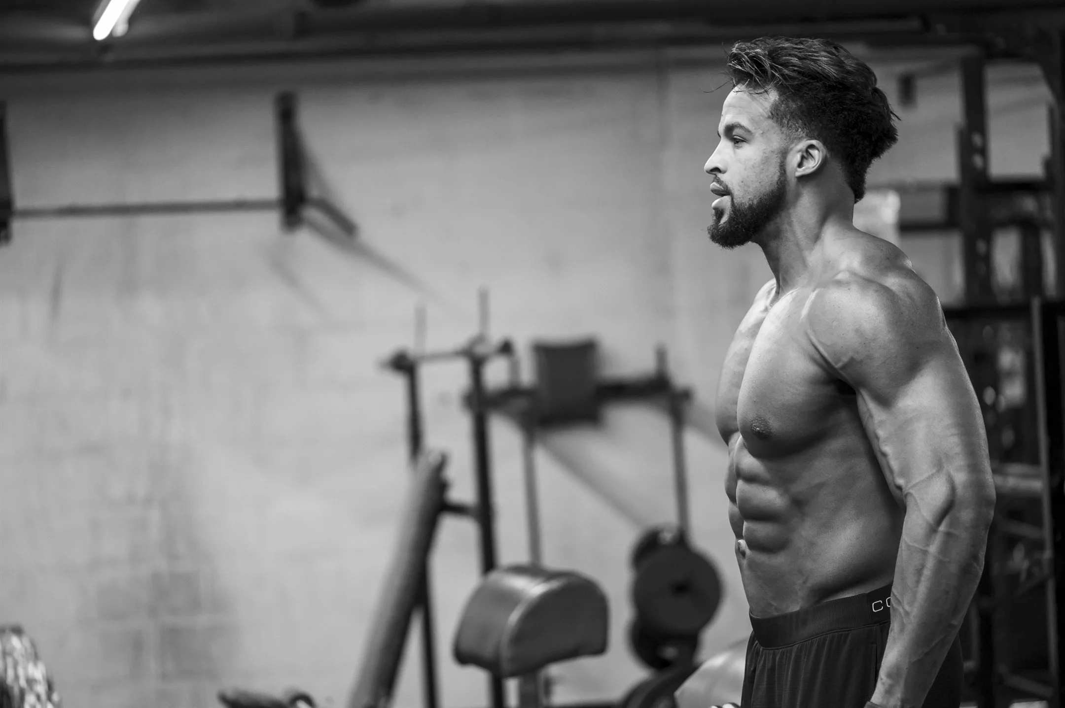 Muscular man doing strength workout in a gym
