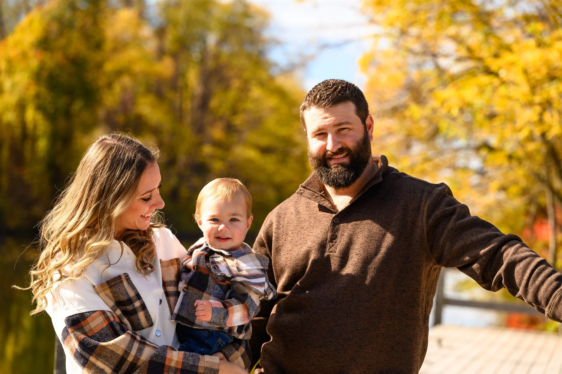 Family with toddler outdoors in autumn, smiling