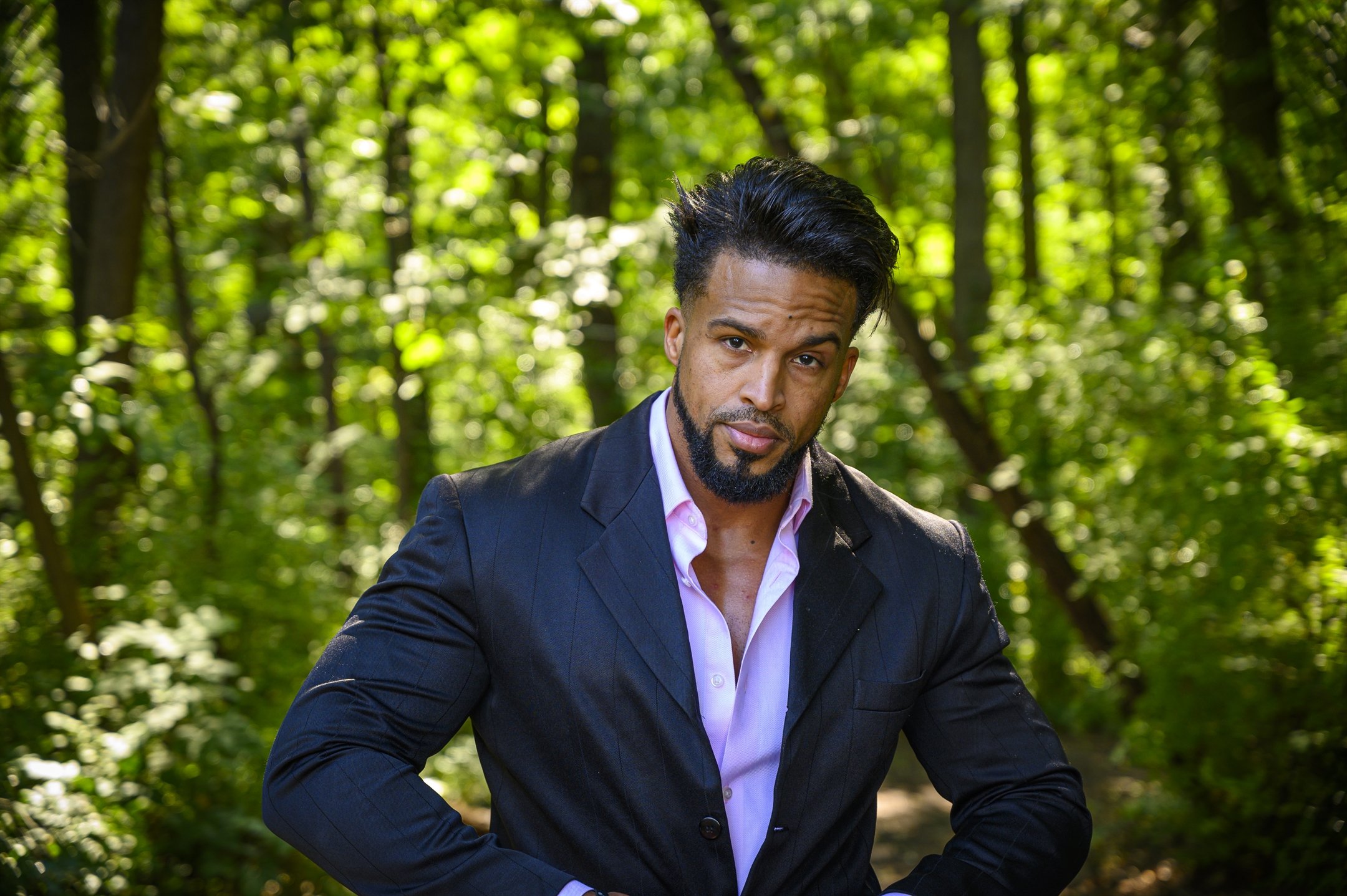 Man in a suit standing in a forest setting