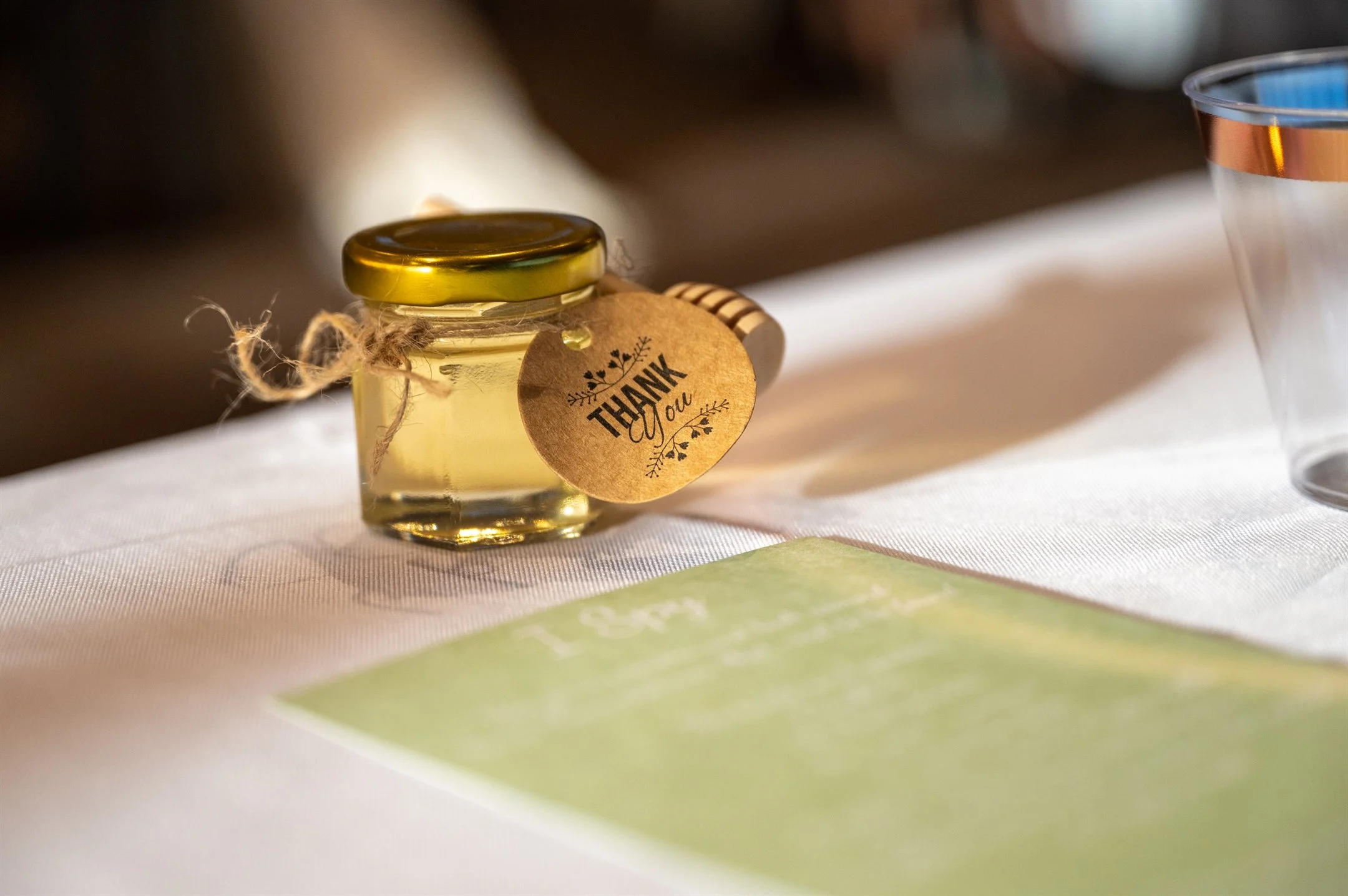 Small honey jar with "Thank You" tag on table