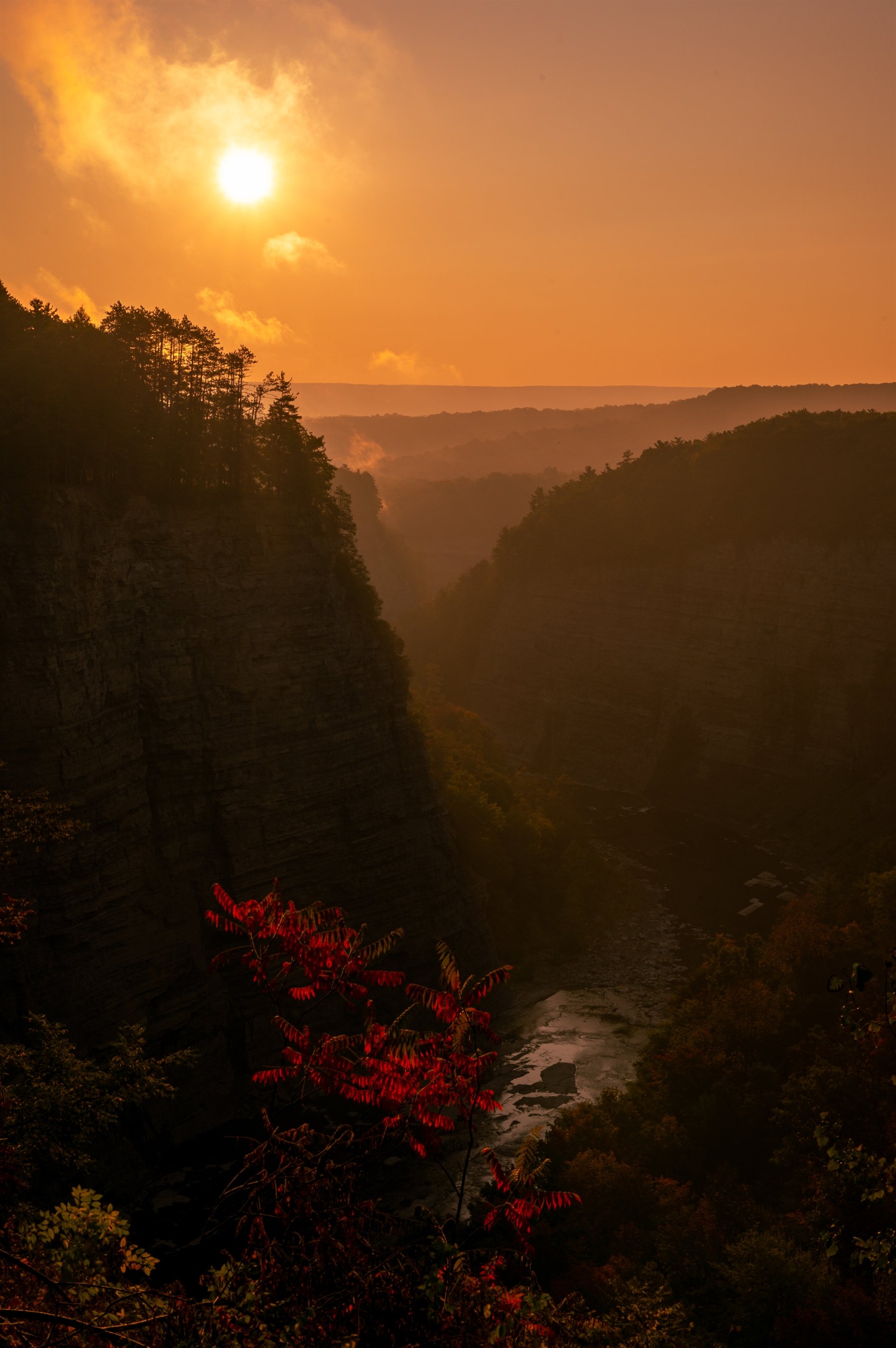 Sunset over a canyon with orange sky and river