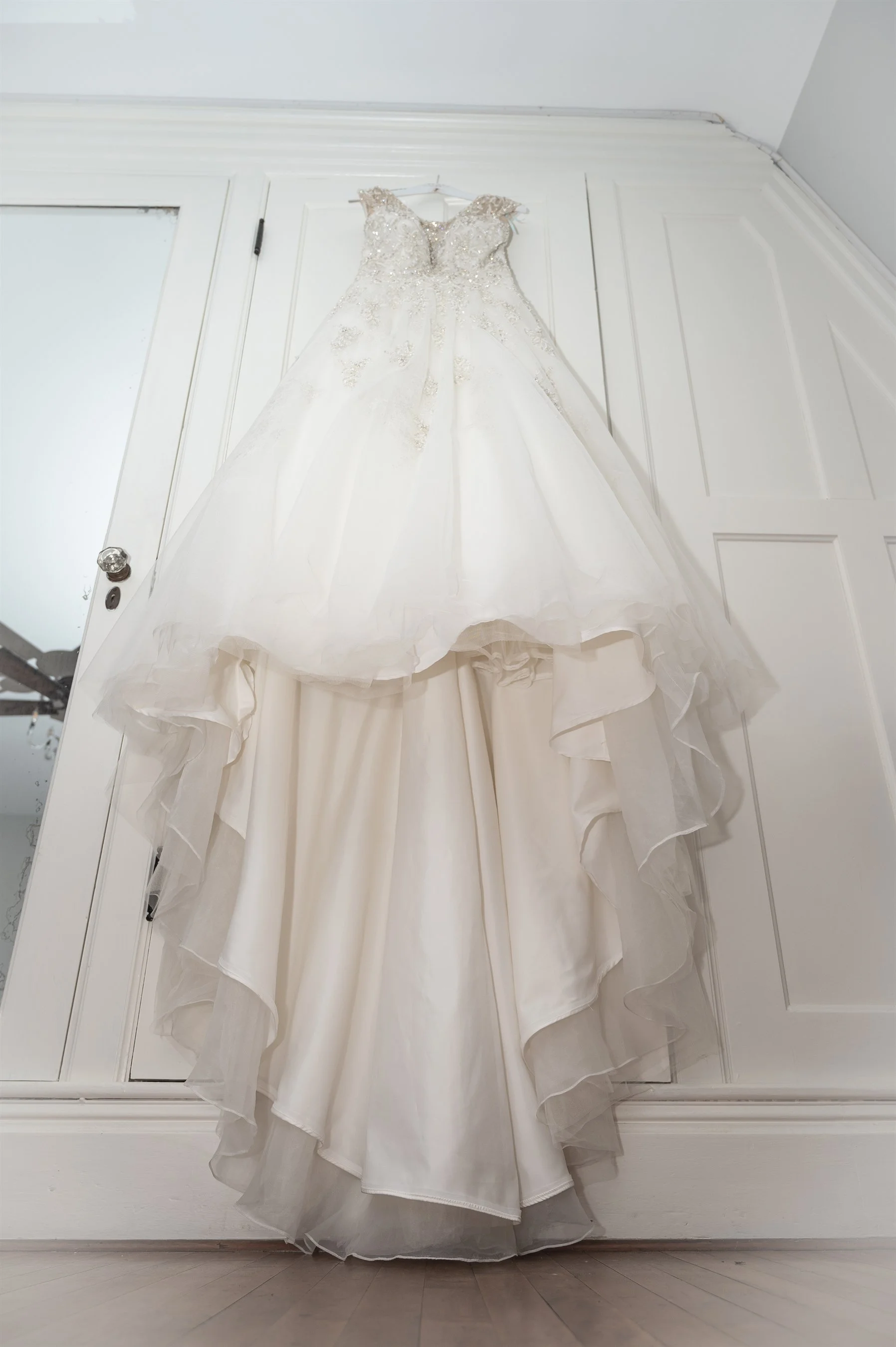 White wedding dress hanging on a door