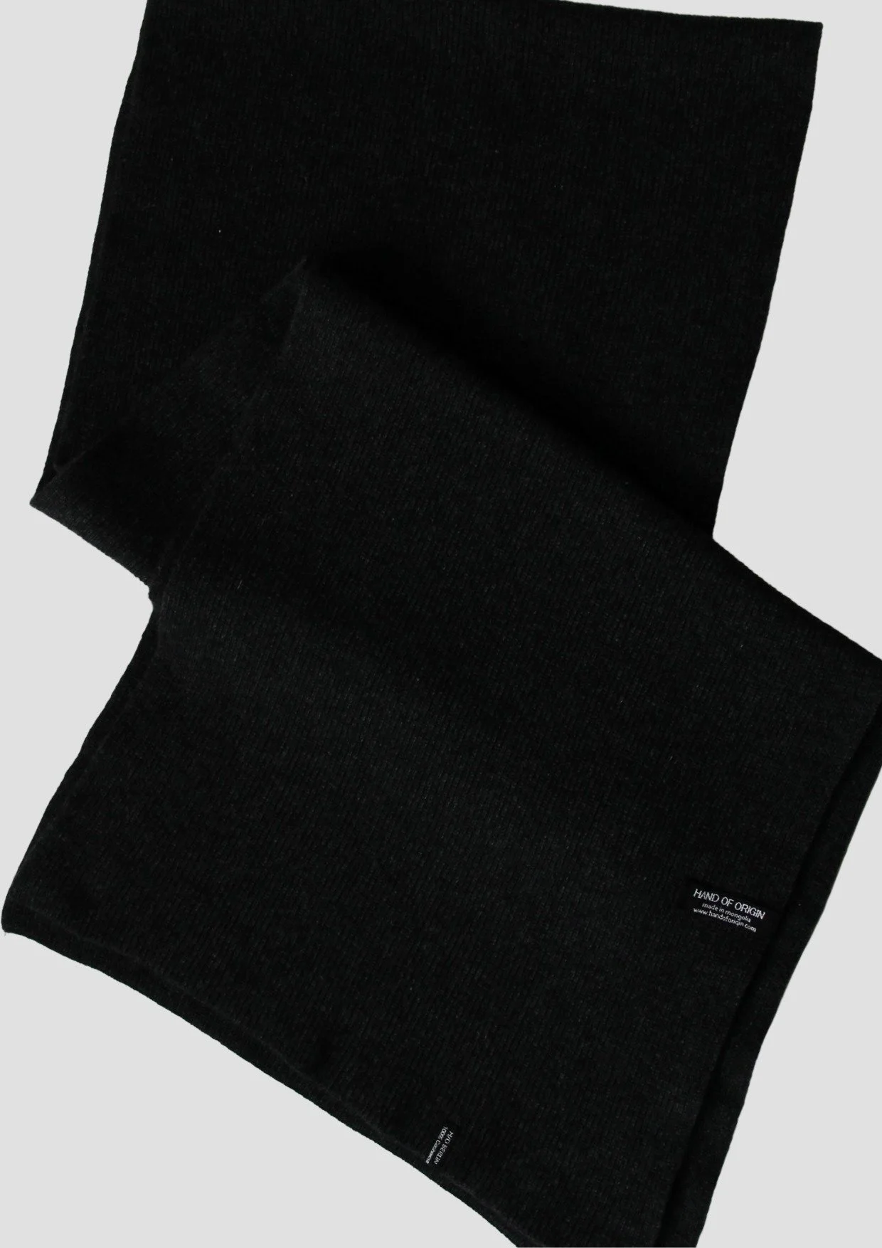 Shop a 100% Mongolian cashmere oversized scarf in black. Ultra-soft, lightweight and warm ribbed knit. Designed in Berlin and made in Mongolia by Hand of Origin.