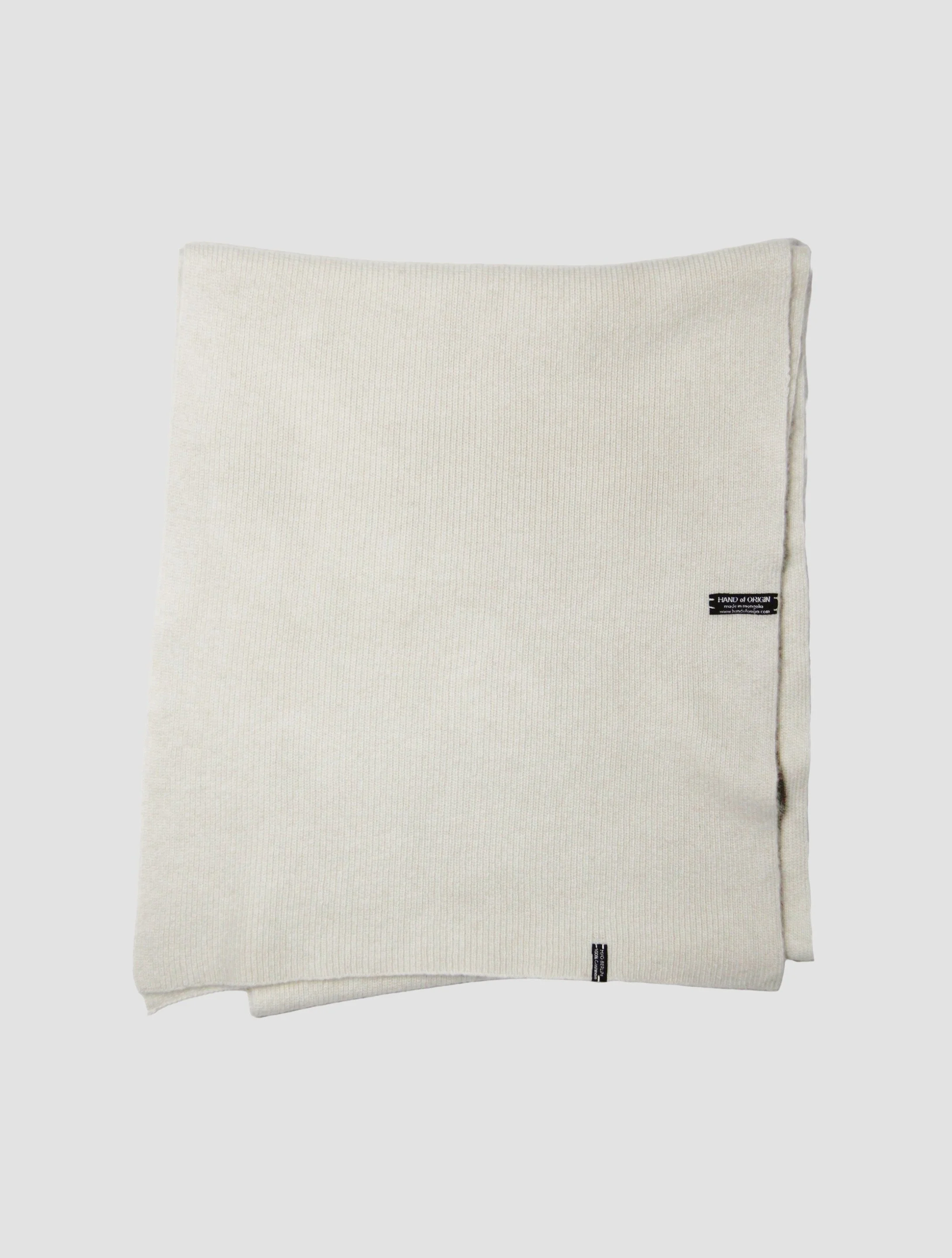 Shop 100% Mongolian cashmere oversized scarf in natural white. Ultra-soft, lightweight, and warm ribbed knit. Designed in Berlin and made in Mongolia by Hand of Origin.