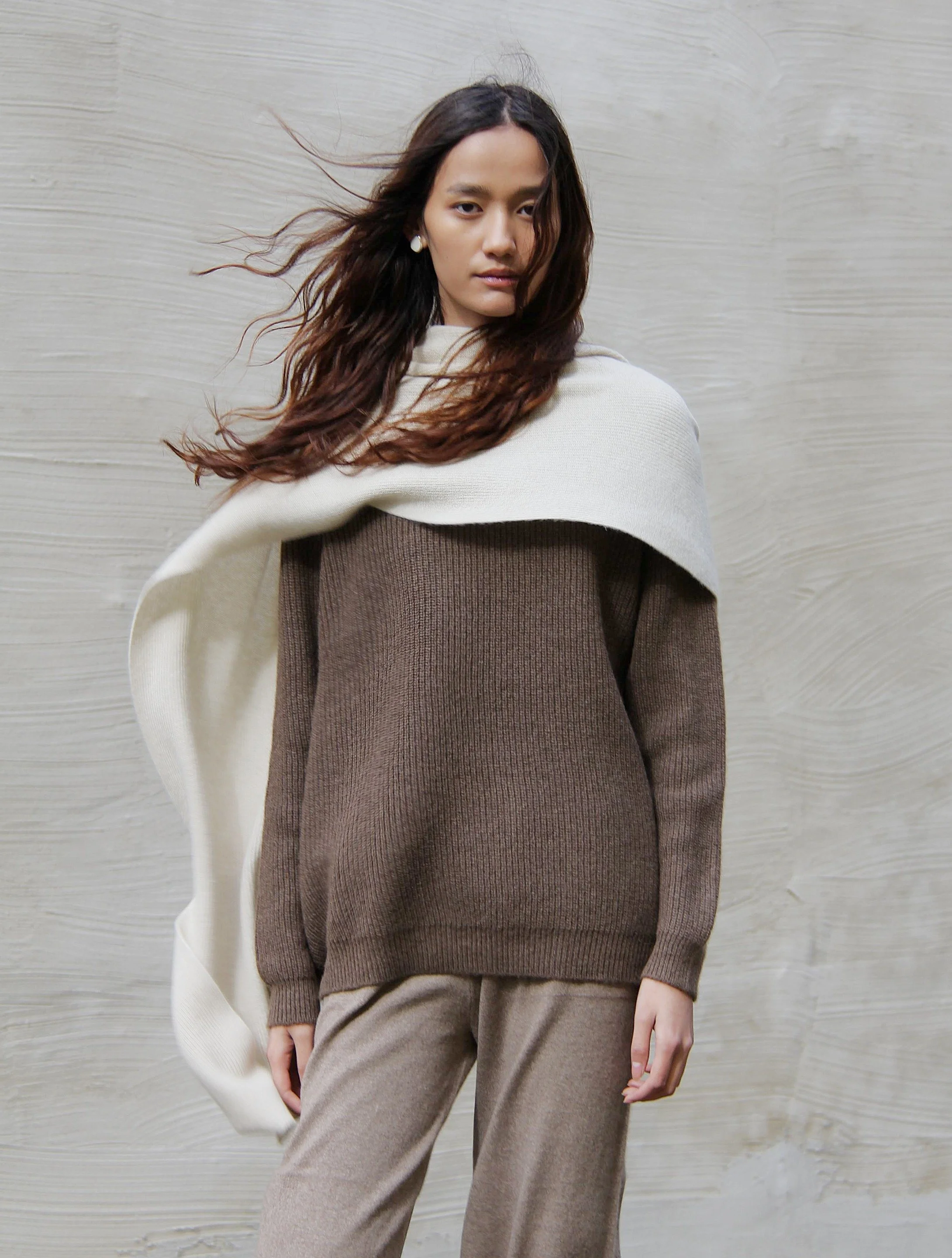 Shop 100% Mongolian cashmere oversized scarf in natural white. Ultra-soft, lightweight, and warm ribbed knit. Designed in Berlin and made in Mongolia by Hand of Origin.