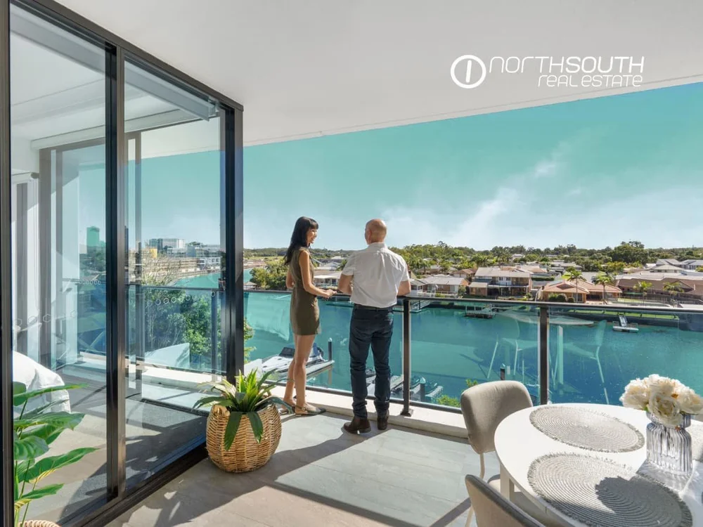 A couple looking at the waterfront views from level 3 of 3303 Waterpoint Residences, Biggera Waters QLD