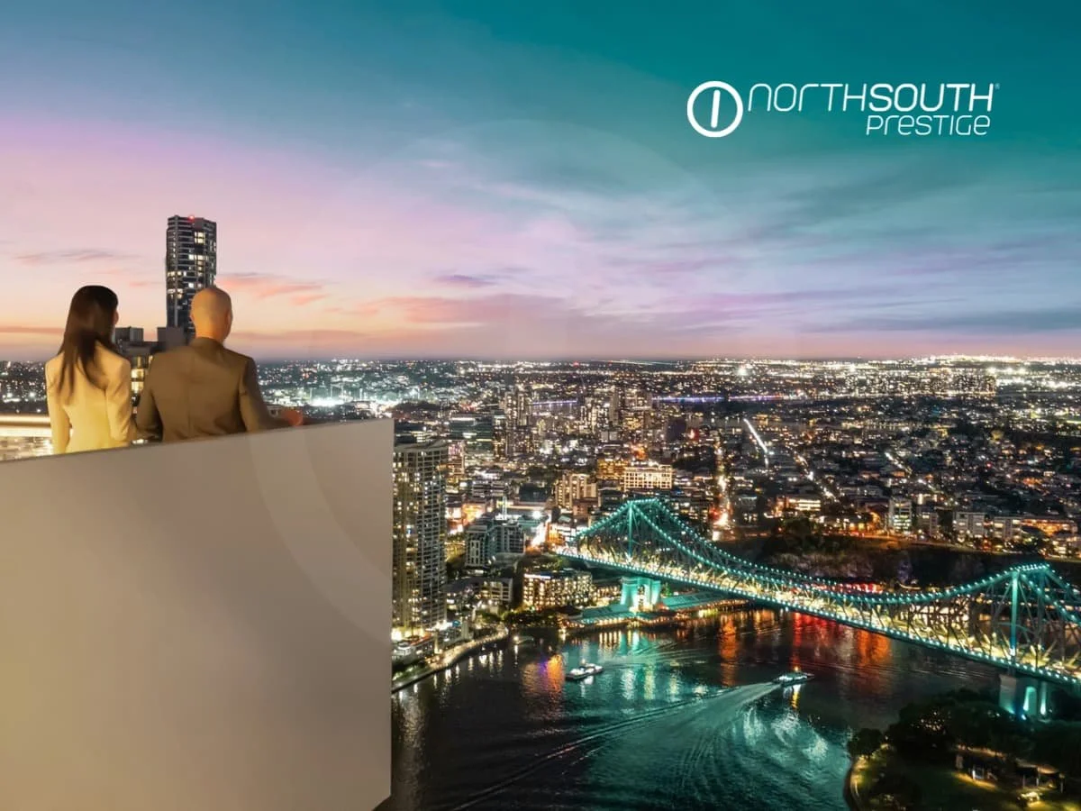 A couple on the balcony looking at twilight views of the lit up Story bridge - Brisbane properties for sale Riparian Plaza apartment 4903 
