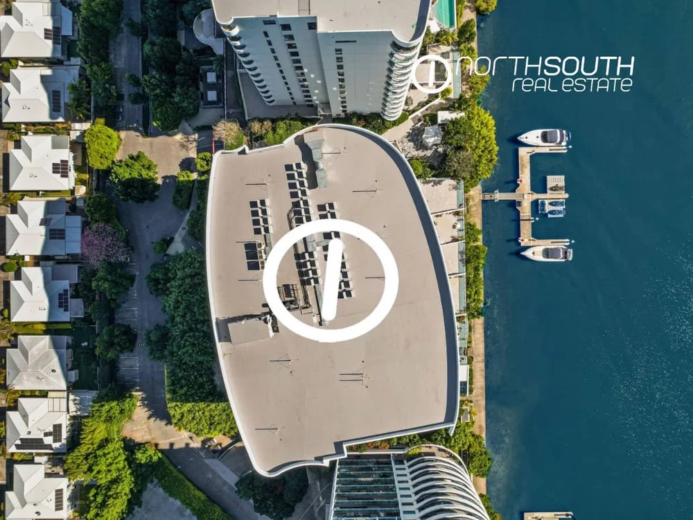 Drone aerial view of Building 3 of Waterpoint Residences in Biggera Waters with canal on one side and residential houses on the other