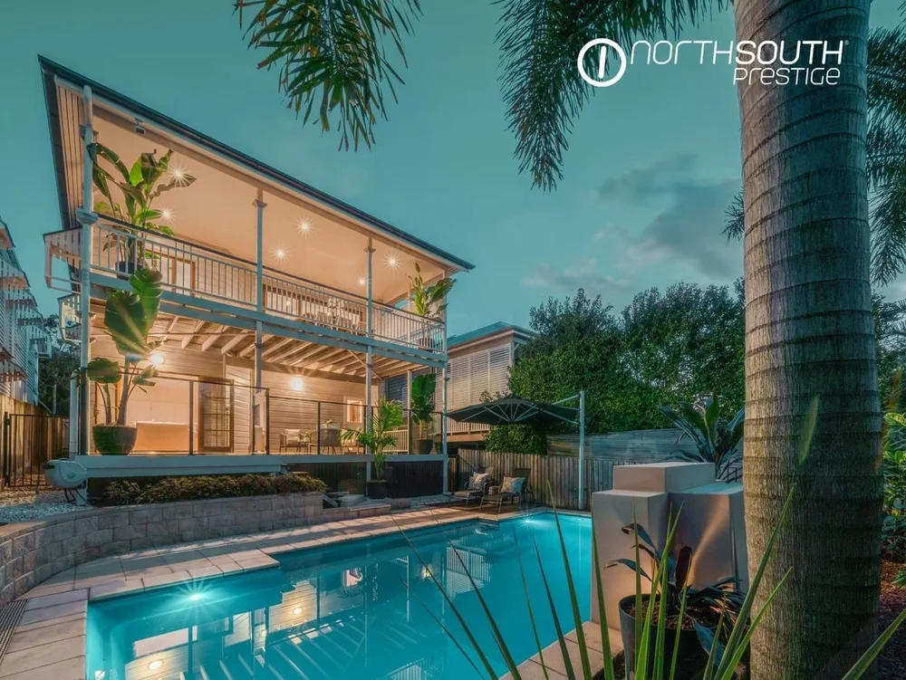 Image of properties for sale Brisbane in Bardon pool at twilight with ambient lighting and outdoor entertaining area.
