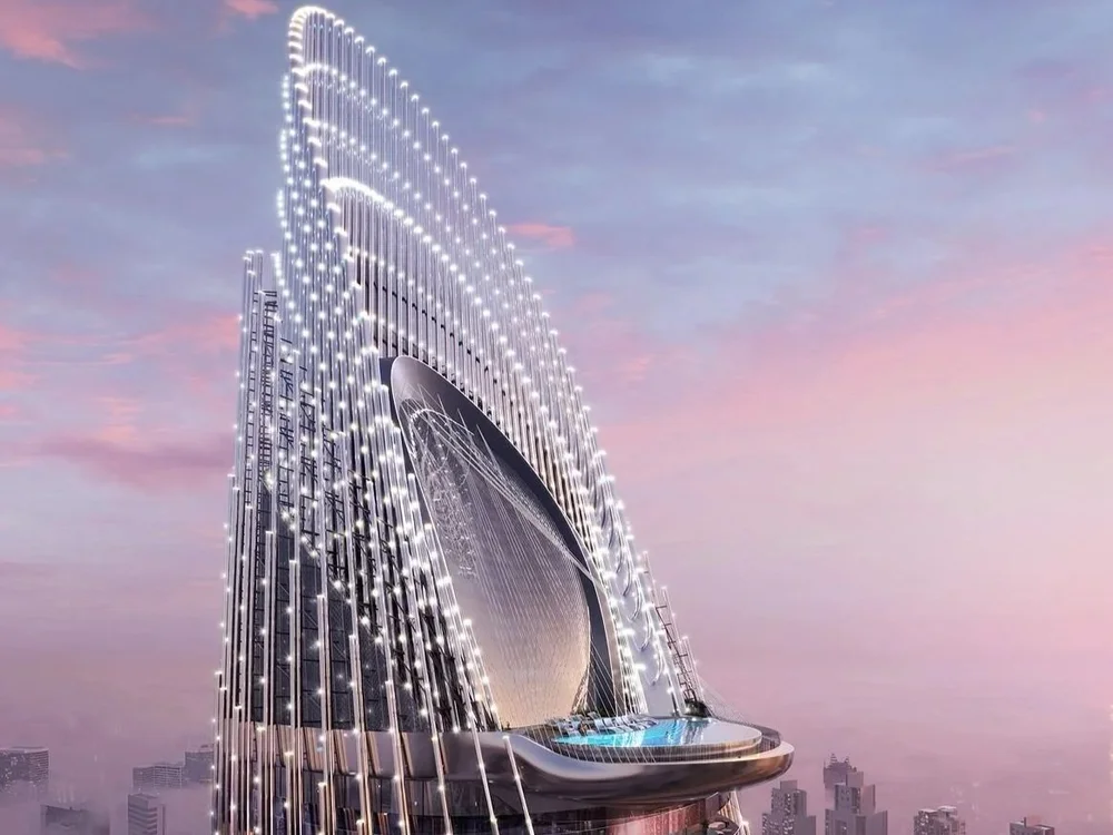 Luxury properties for sale Dubai Binghatti Skyblade – tower top illuminated at twilight with skyline view