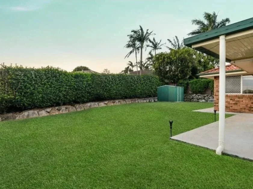 Rear exterior view of family home on generous block in Griffin QLD with covered patio and landscaped lawn 