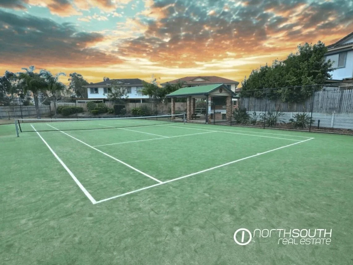 Communal tennis court and landscaped grounds within Thorneside townhouse complex, Queensland