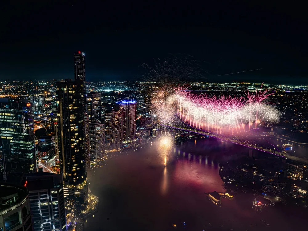Brisbane city skyline across the river, the market the 2032 Olympic infrastructure programme reshapes.