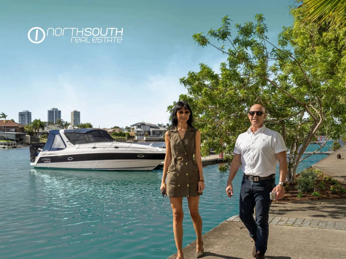A couple walking along the canal walk at Waterpoint Residences, Biggera Waters QLD. 
