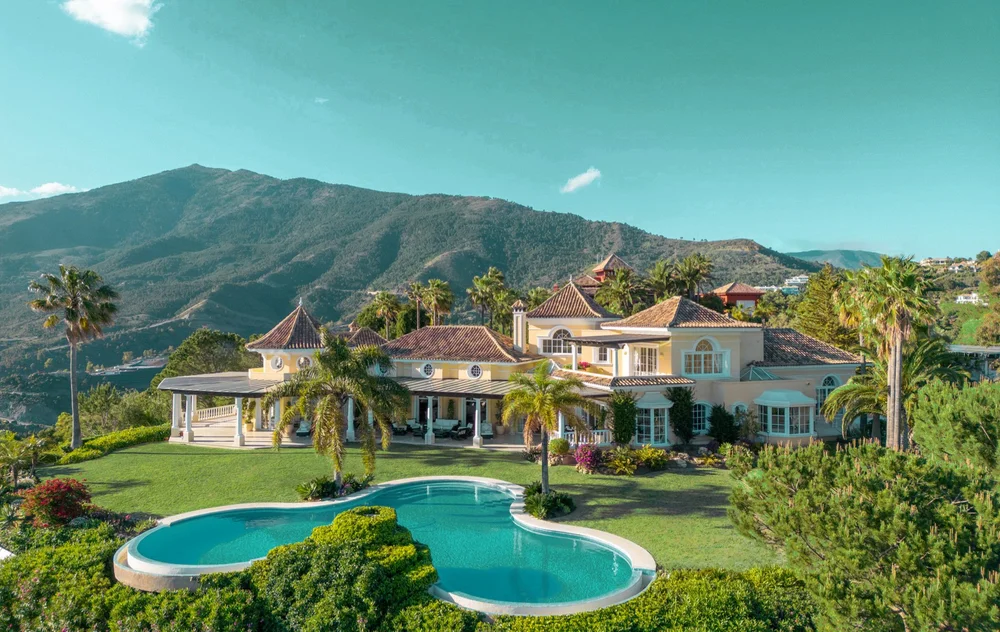 Terrasse ombragée de la villa, la table dressée au-dessus des jardins.