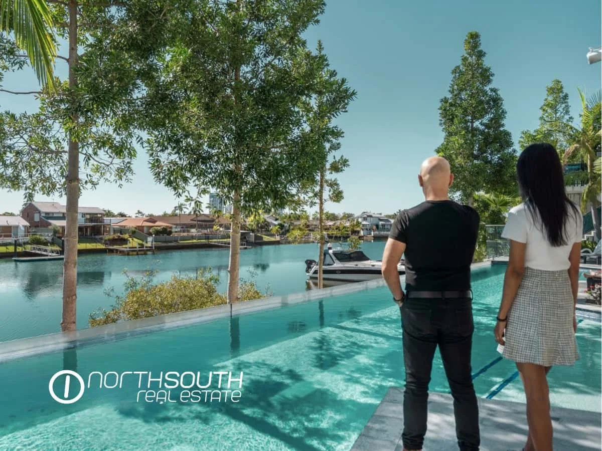 A couple looking at the canal and infinity pool in the facilities of Waterpoint Residences, Biggera Waters QLD.