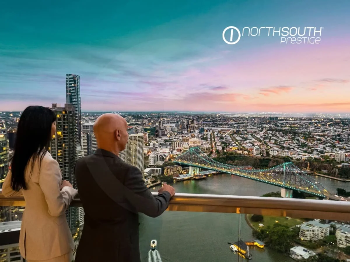 A couple enjoying sunset views from the balcony towards the Story bridge - Brisbane properties for sale Riparian Plaza apartment 4903 