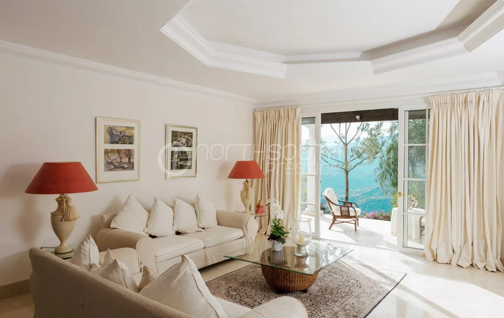Guest suite in villa in Marbella Spain featuring stunning views of the sea and surrounding mountains through large windows.
