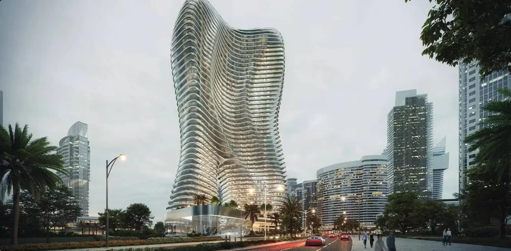 A futuristic high-rise building with a wavy, curvilinear design in an urban cityscape, surrounded by other tall modern buildings and palm trees.